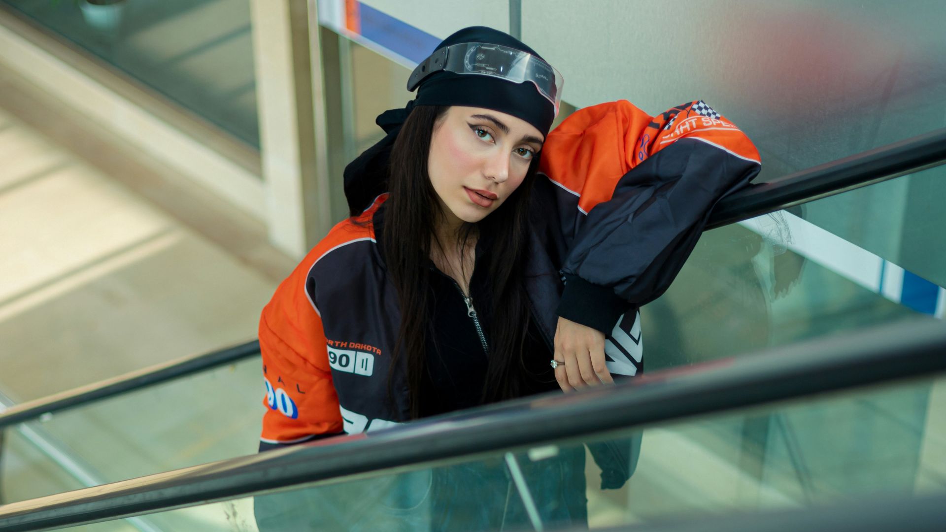 A woman riding an escalator down a flight of stairs