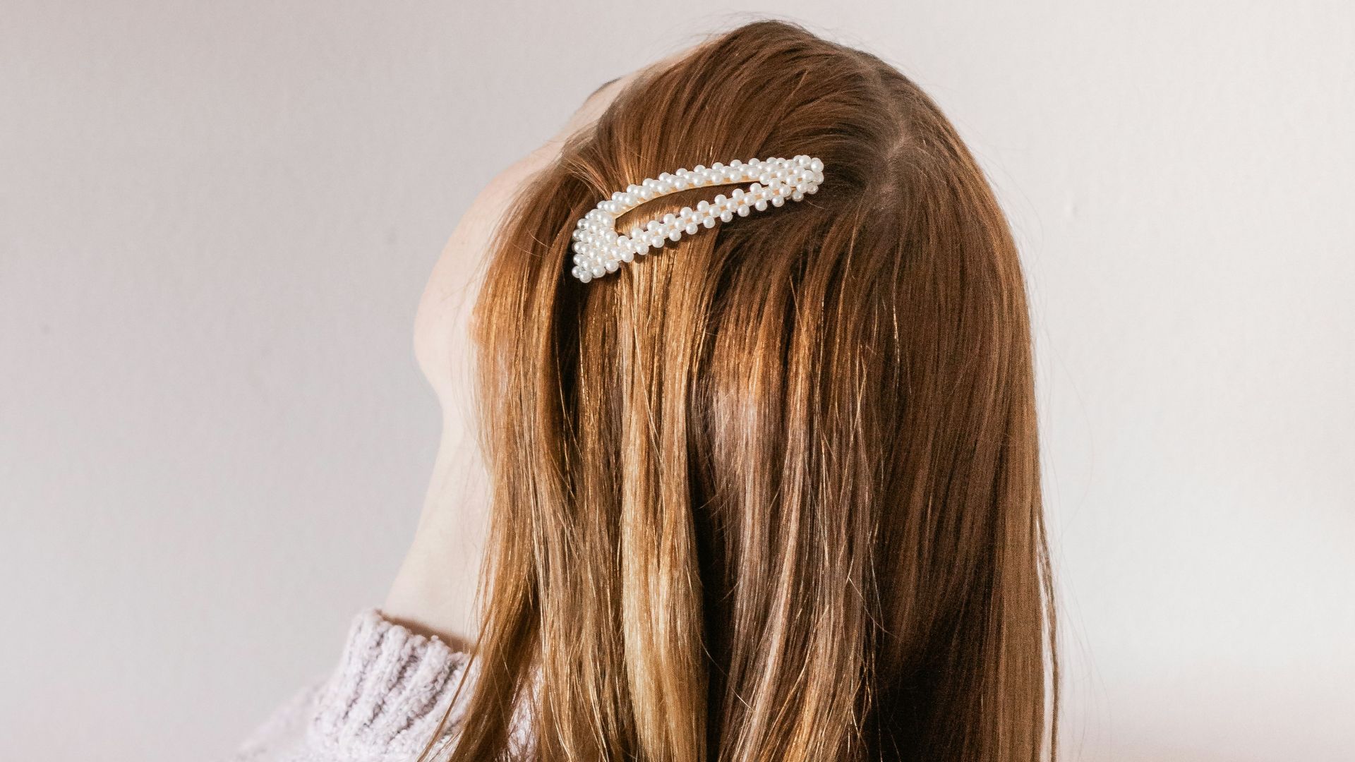 woman in white shirt with brown hair tied
