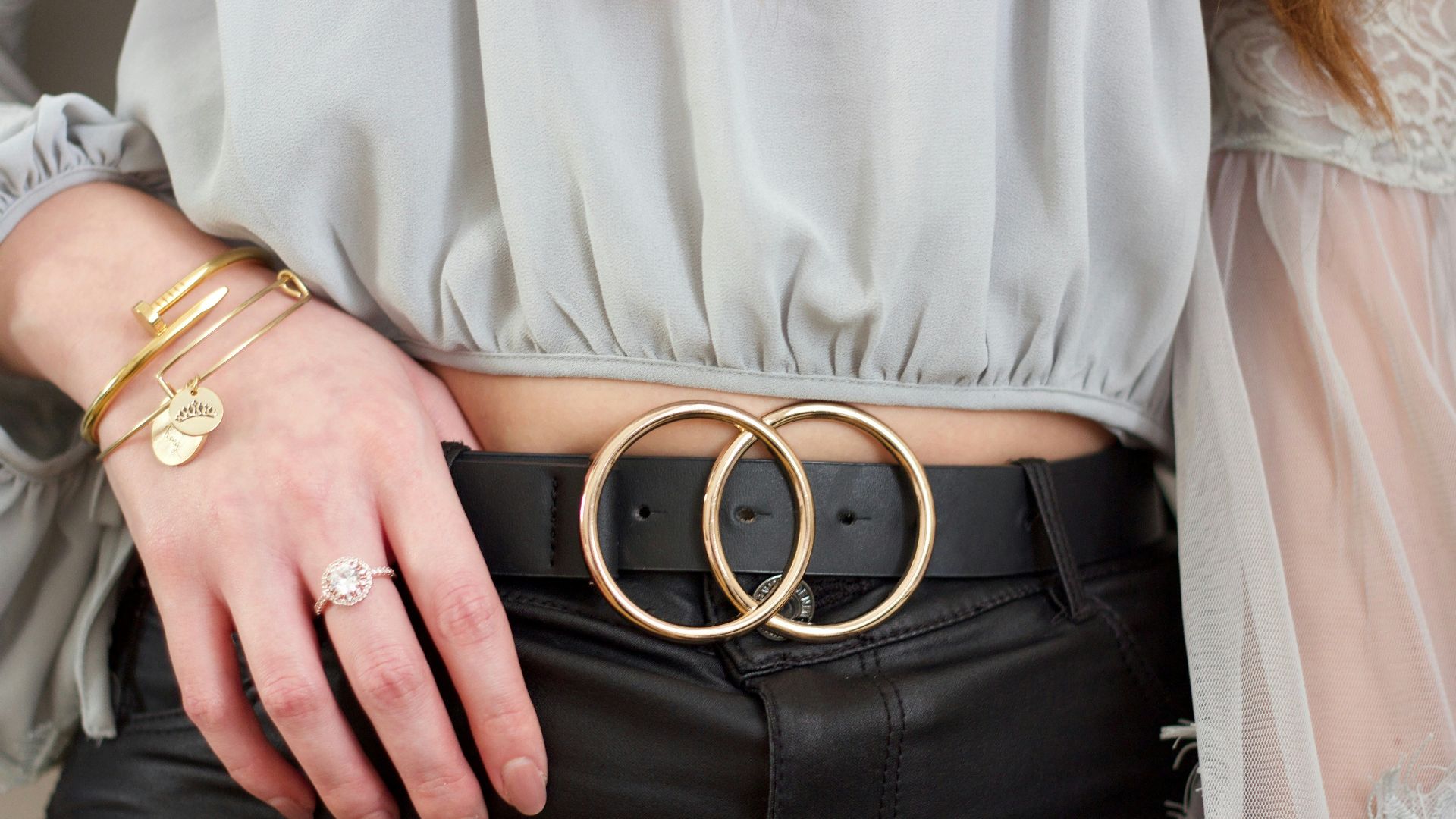 person wearing gray shirt and black leather belt