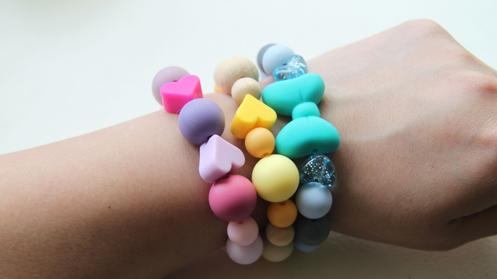 person wearing silver and pink beaded bracelet