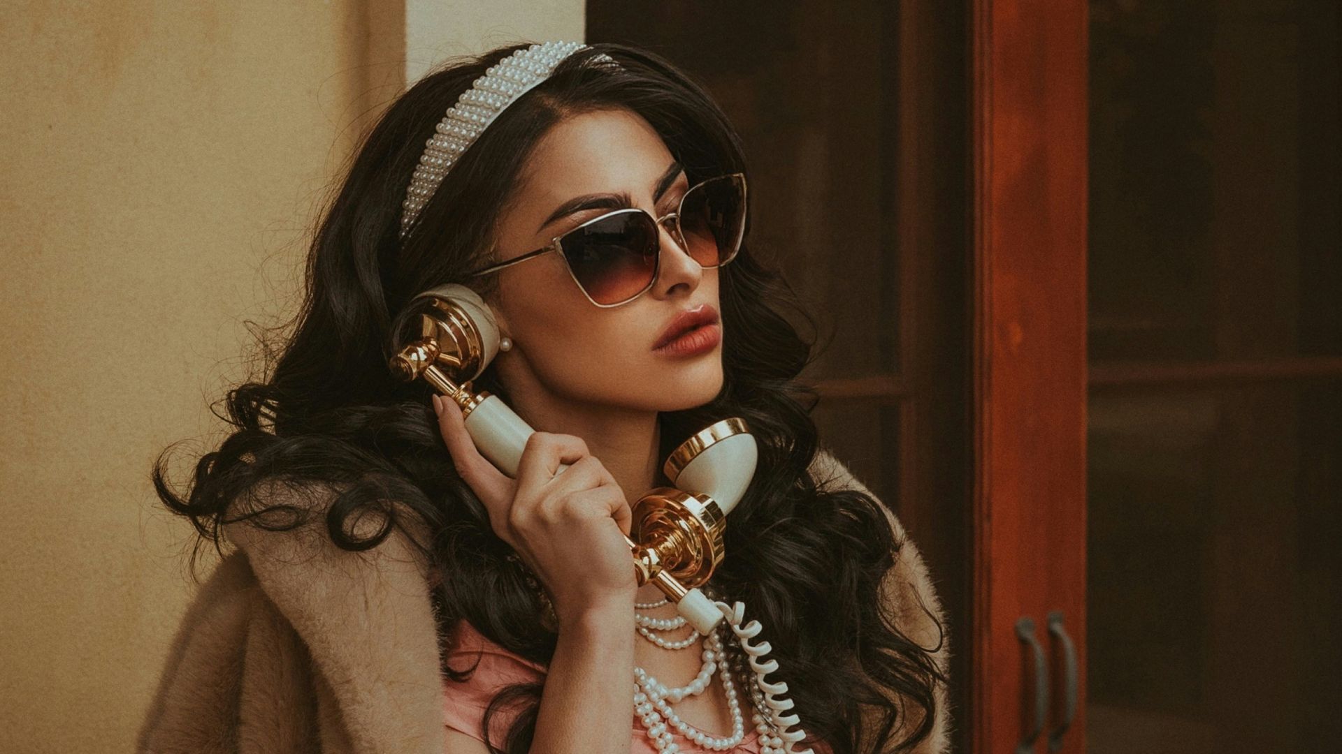 a woman in a pink dress talking on a phone