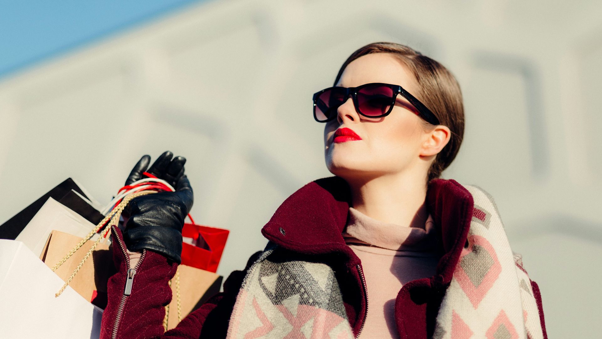 shallow focus photography of woman holding shopping bags during day