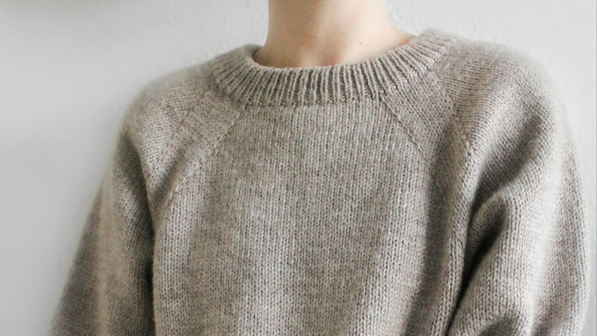 a person wearing a grey sweater