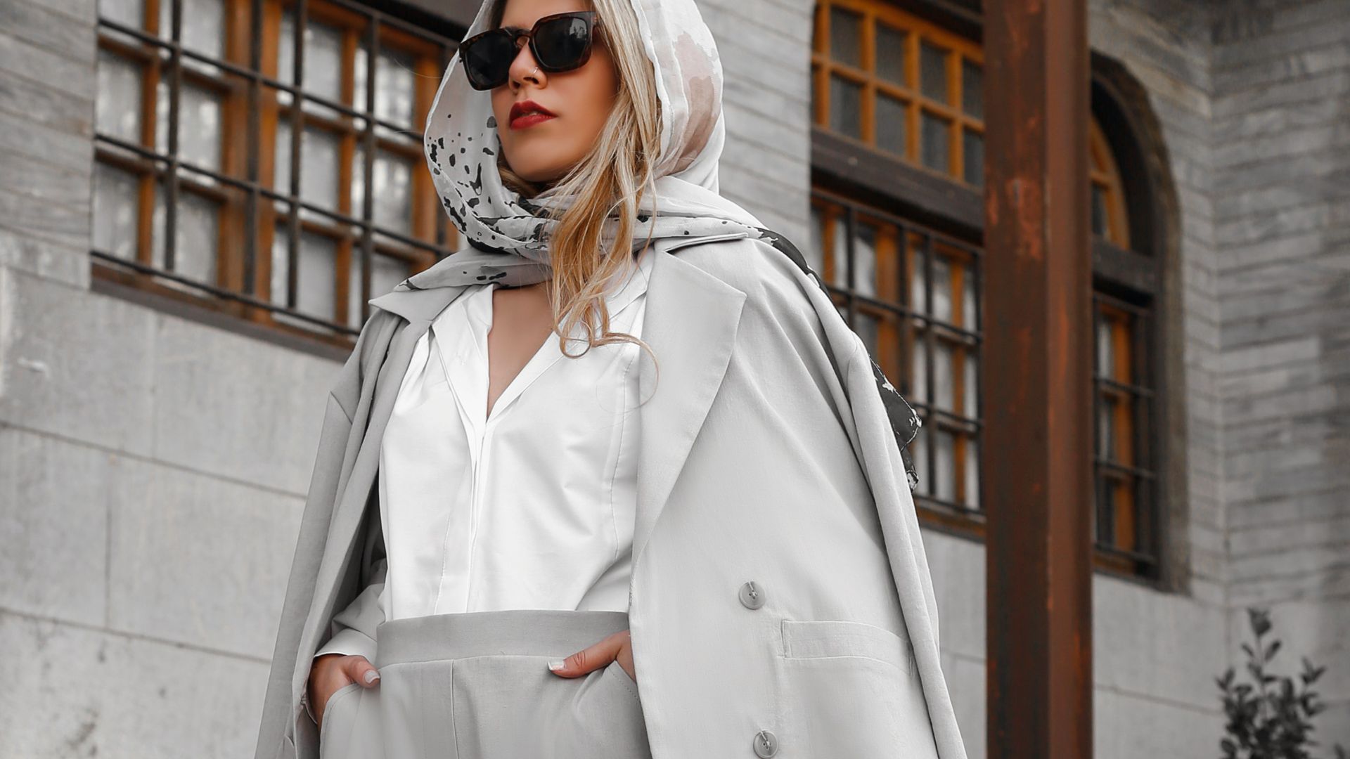 woman in white coat standing on gray concrete stairs