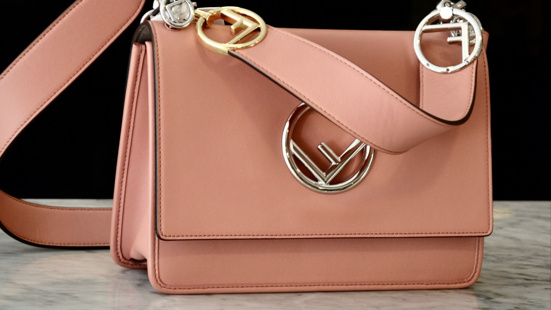 a pink purse sitting on top of a marble counter