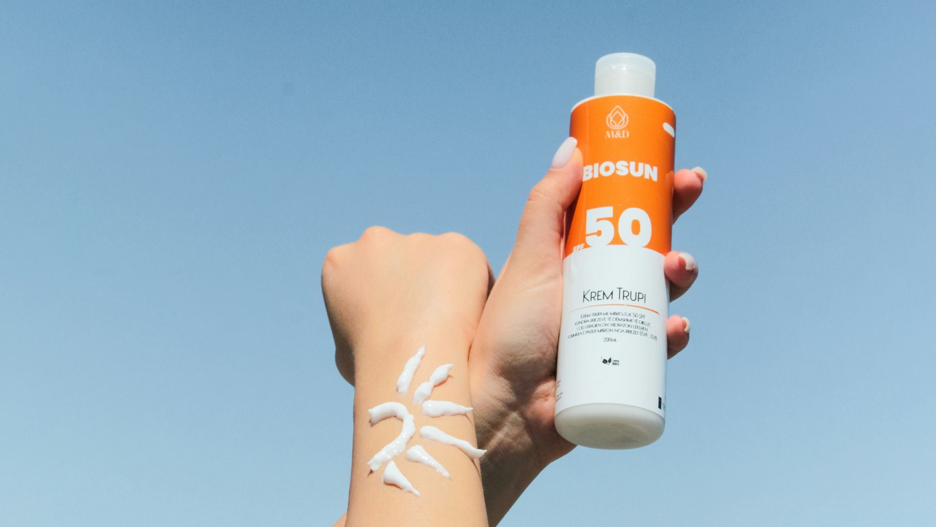 a person holding a bottle of sunscreen in their hand
