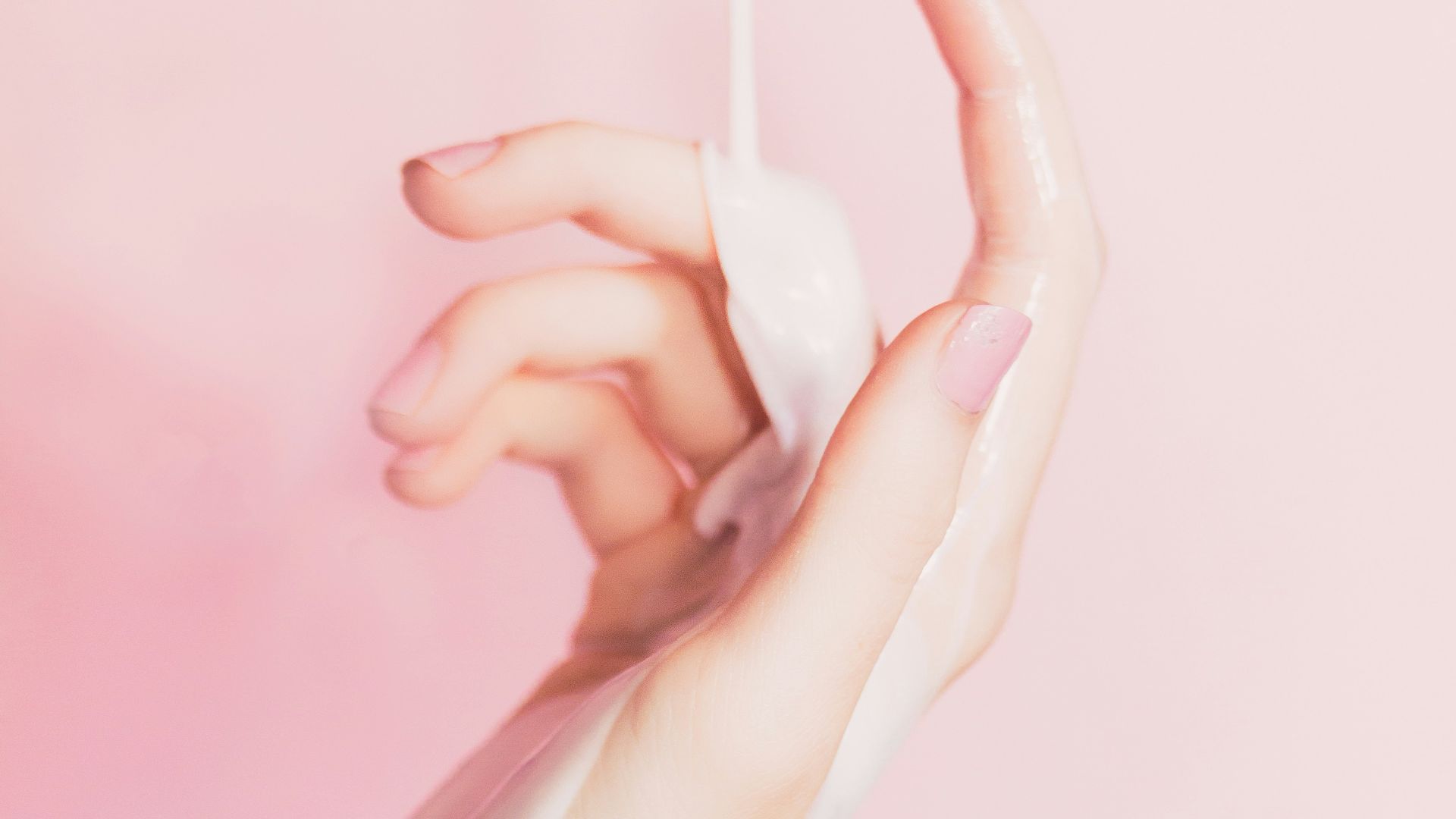 a woman's hand holding a bottle of lotion