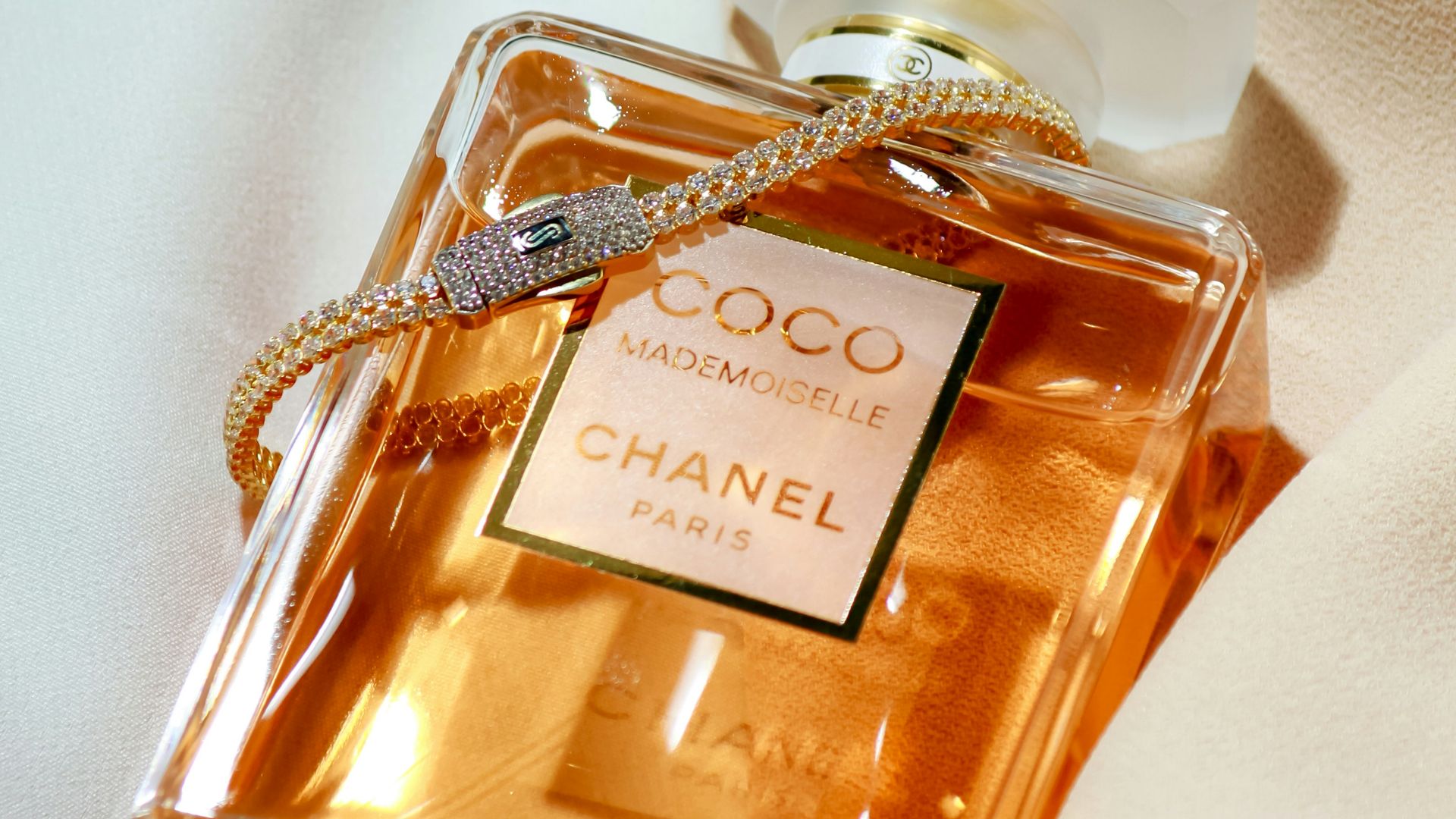 a bottle of perfume sitting on top of a bed