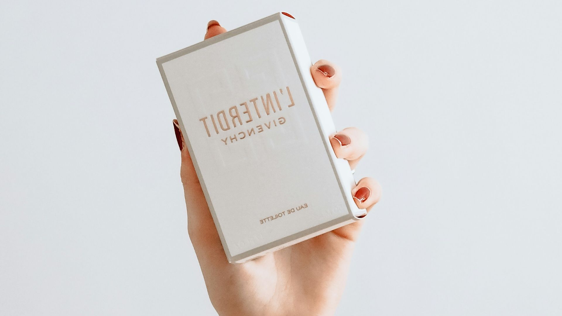 woman in white long sleeve shirt holding white box