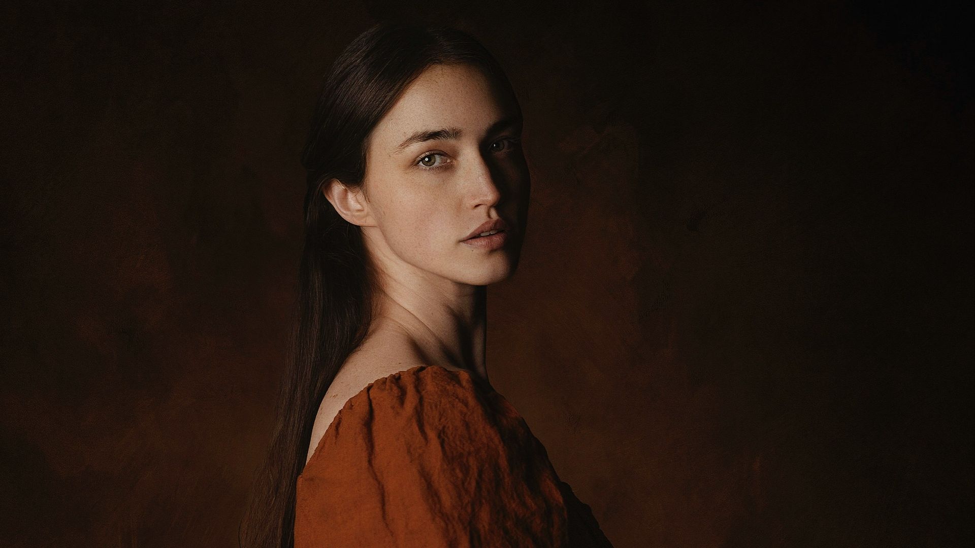 a woman in a brown dress poses for a picture