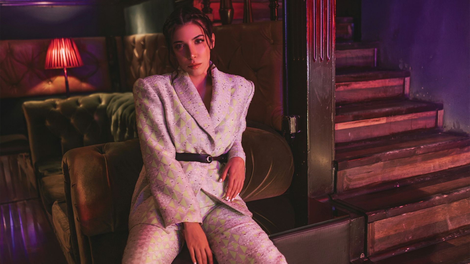 man in gray coat sitting on brown wooden chair