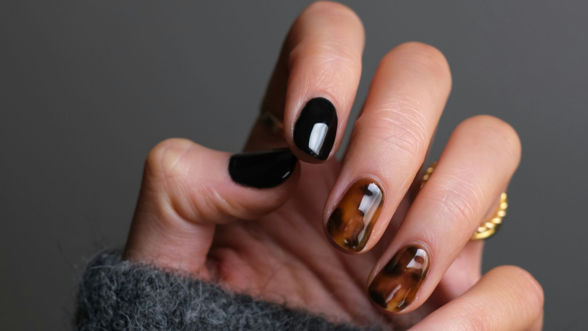 person wearing gold ring holding black textile