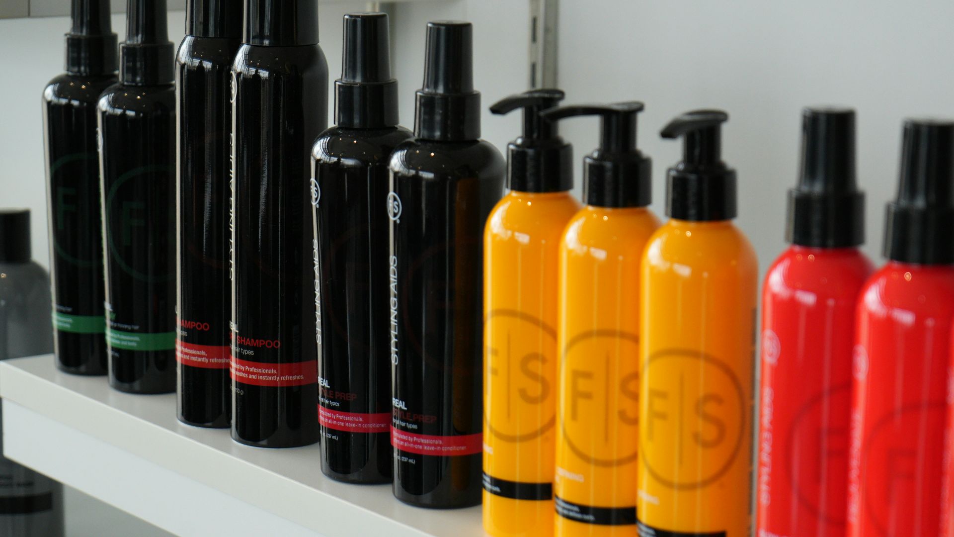 Hair care products are displayed on a shelf.