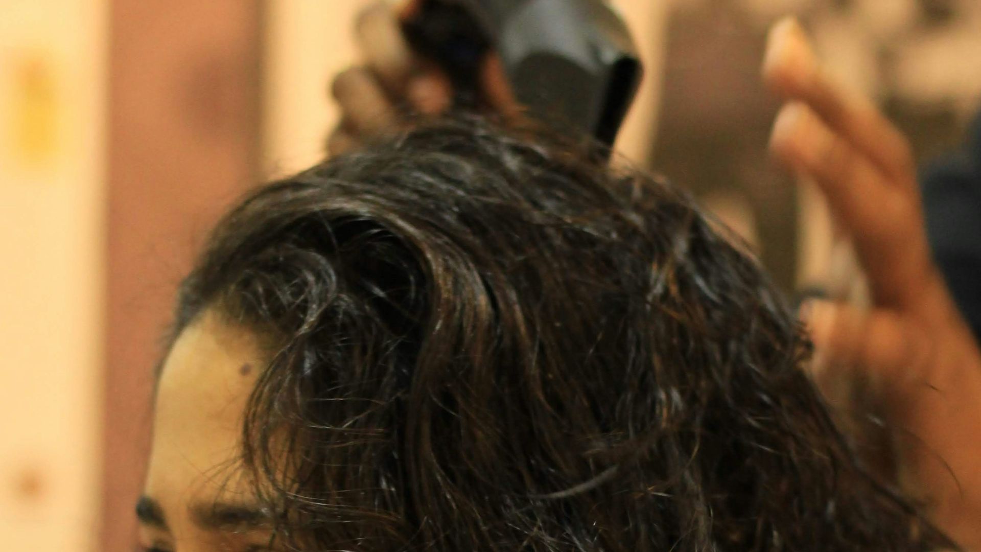 A woman getting her hair cut at a salon