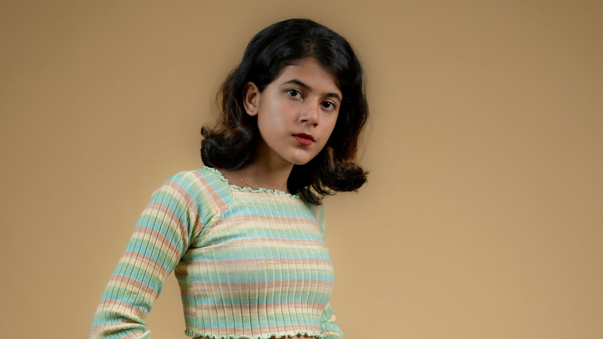 a woman in a striped shirt and denim skirt