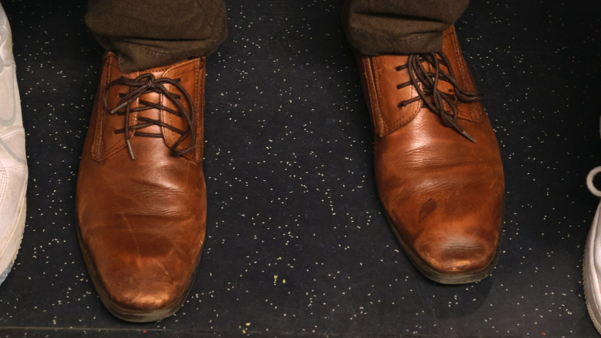 three people standing next to each other wearing brown and white shoes
