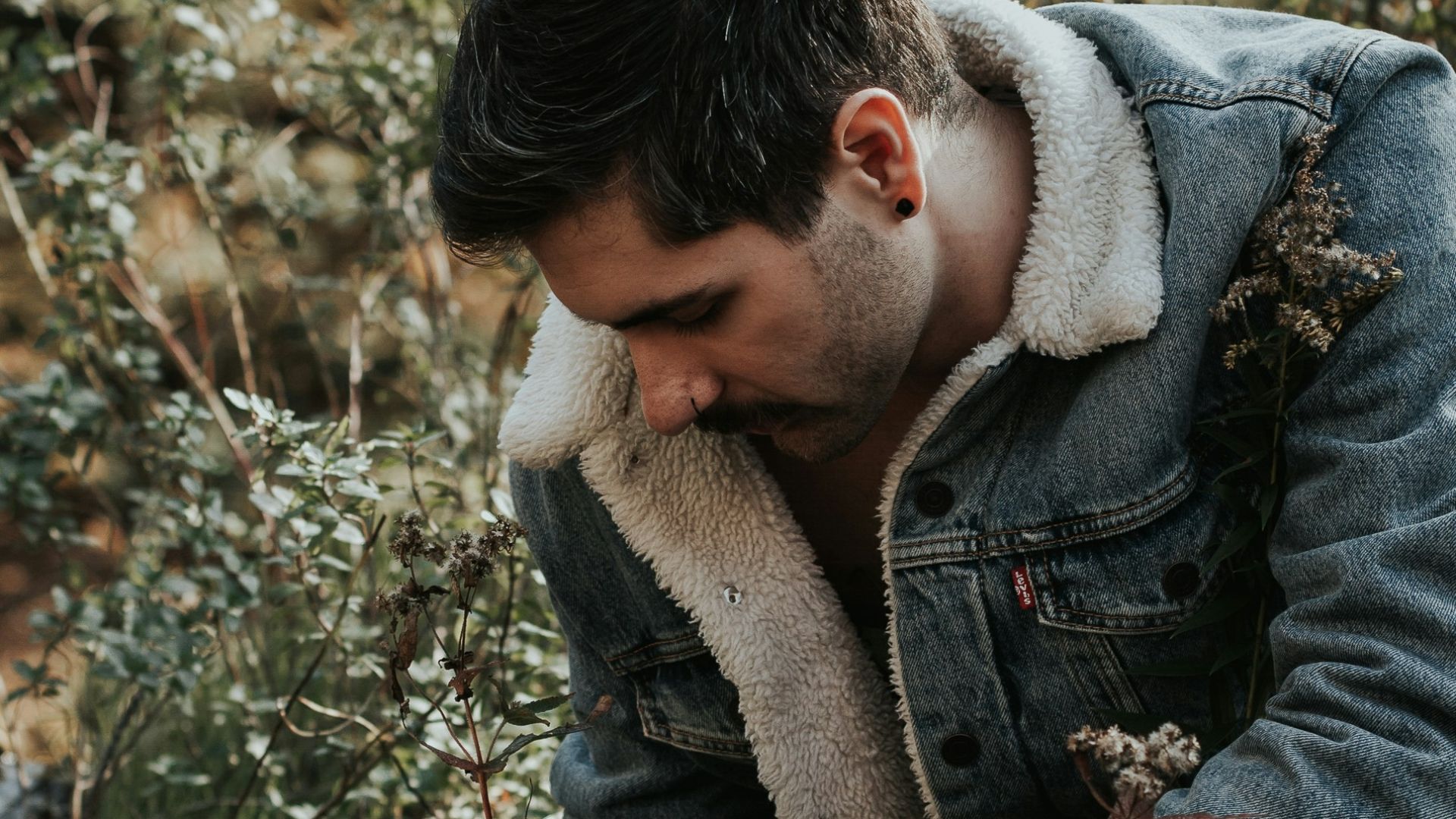 man picking up dried leaves
