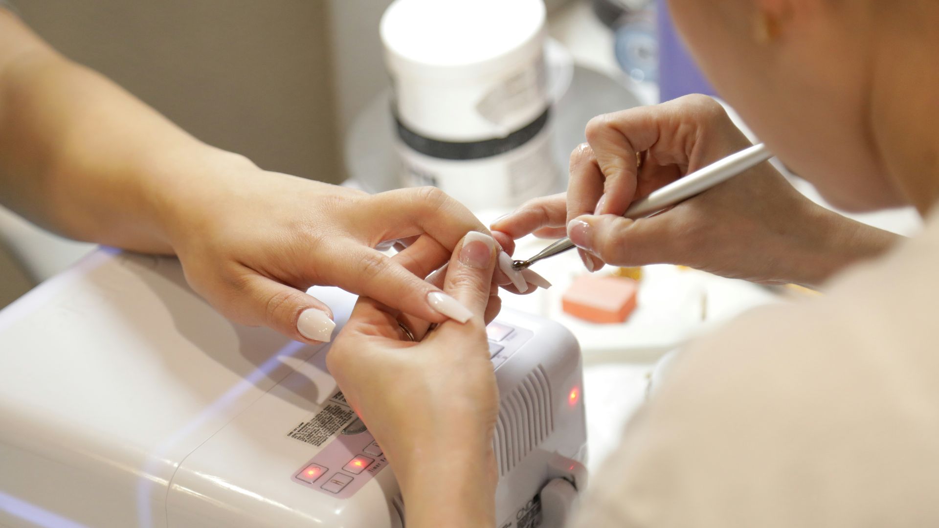 a woman getting her nails done at a nail salon