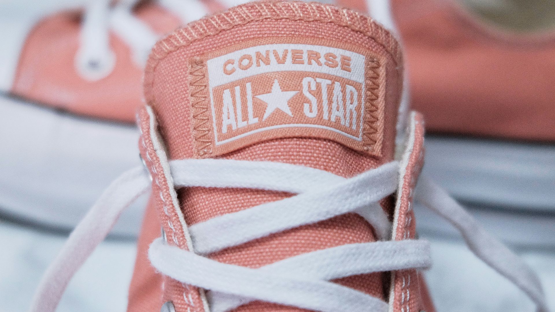 a pair of pink converse sneakers with white laces