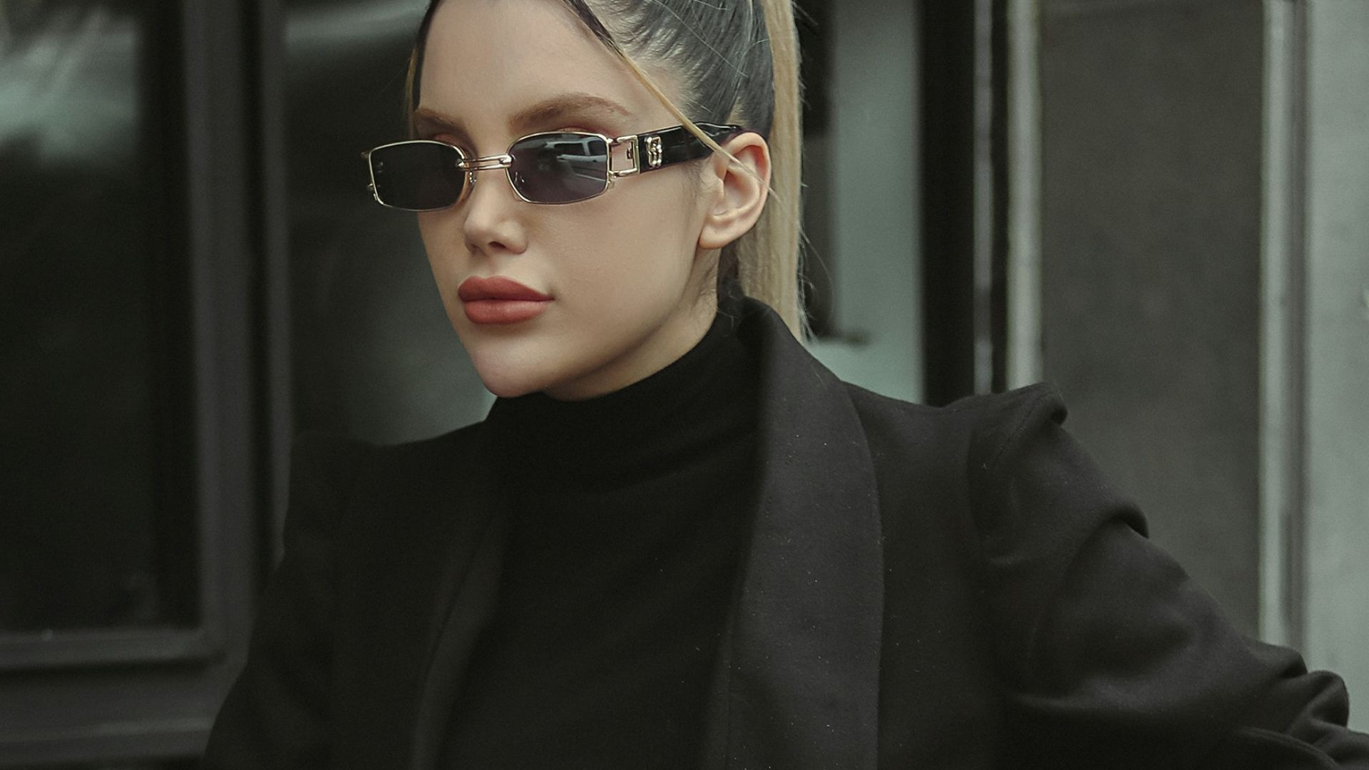a woman sitting at a table wearing a black outfit