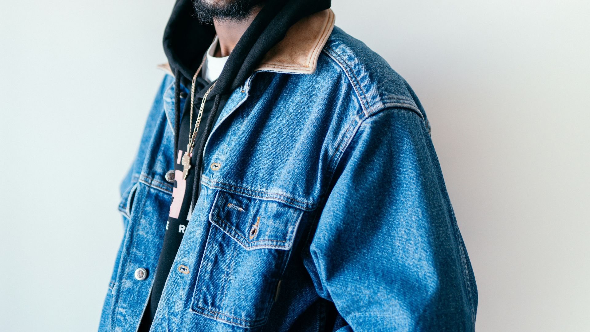 man in blue denim jacket wearing black cap