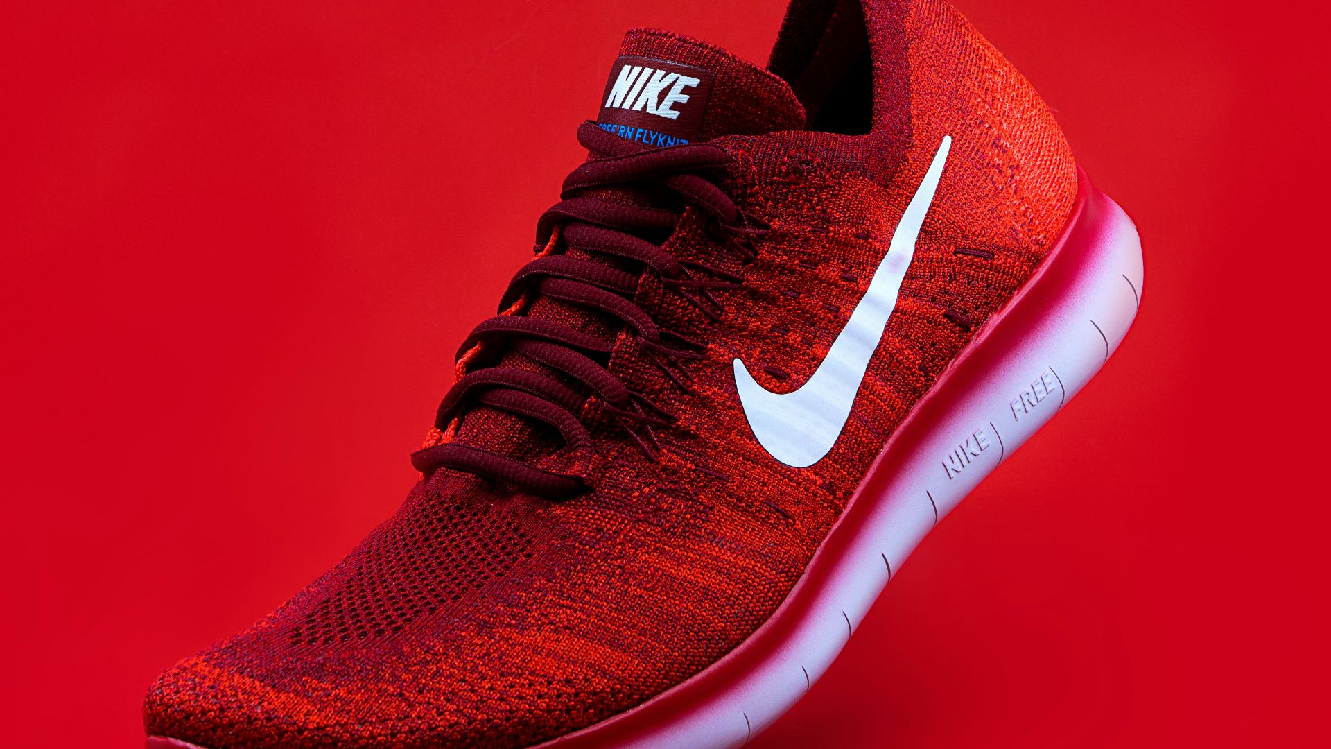unpaired red Nike sneaker