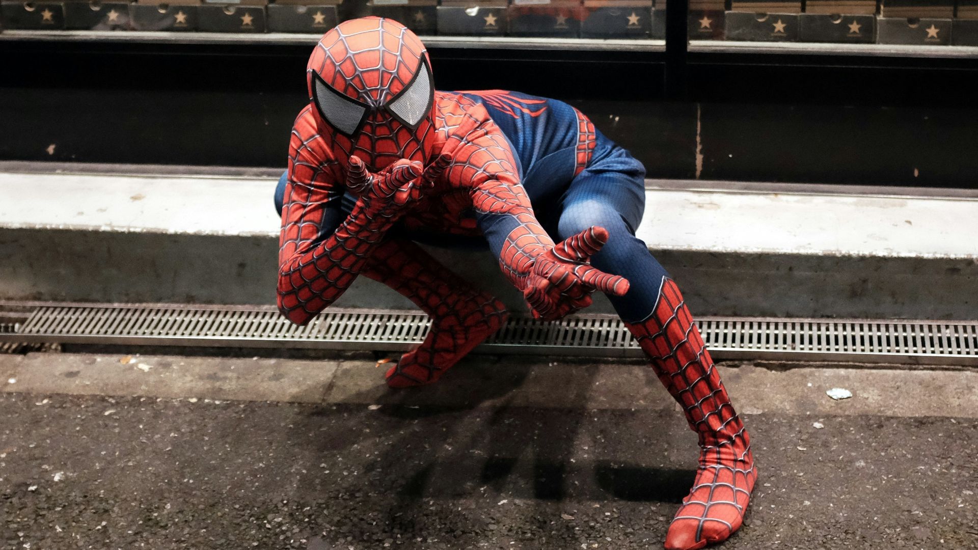 a man dressed as a spiderman crouching down