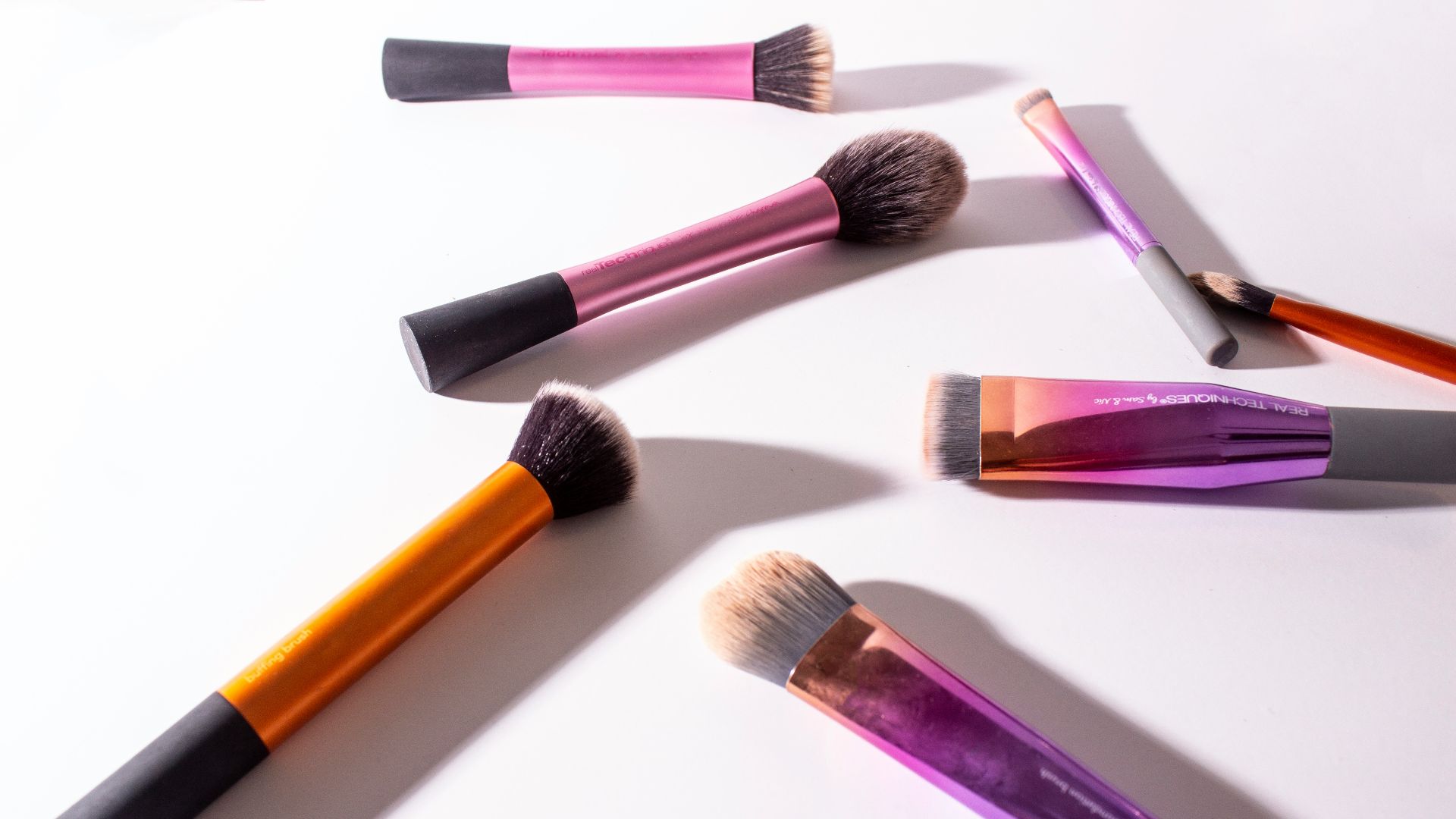 assorted-color makeup brush on white surface