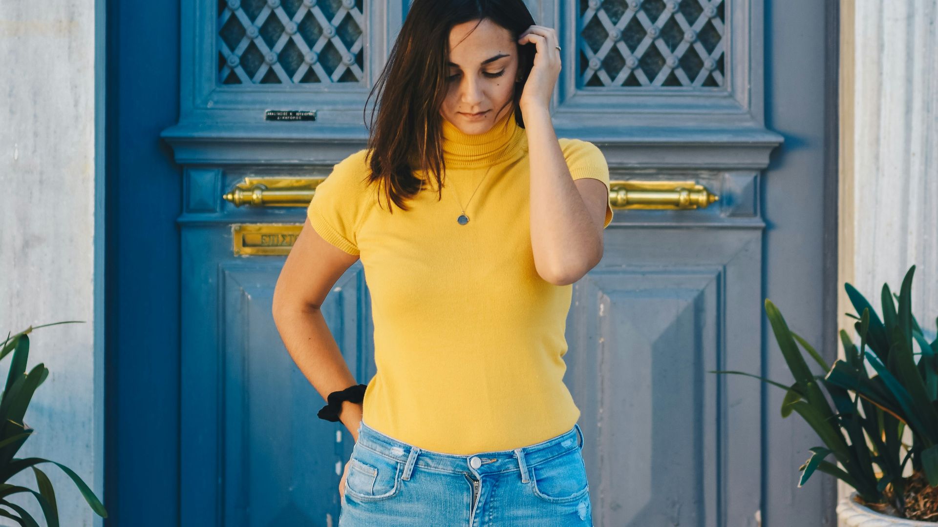 woman standing outside door while holding hair
