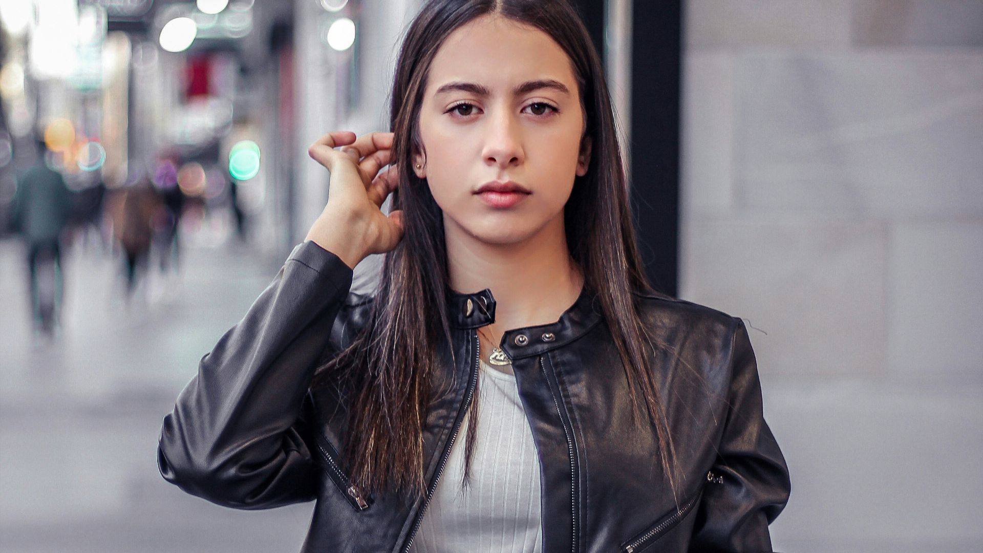 woman in black leather jacket standing and smiling