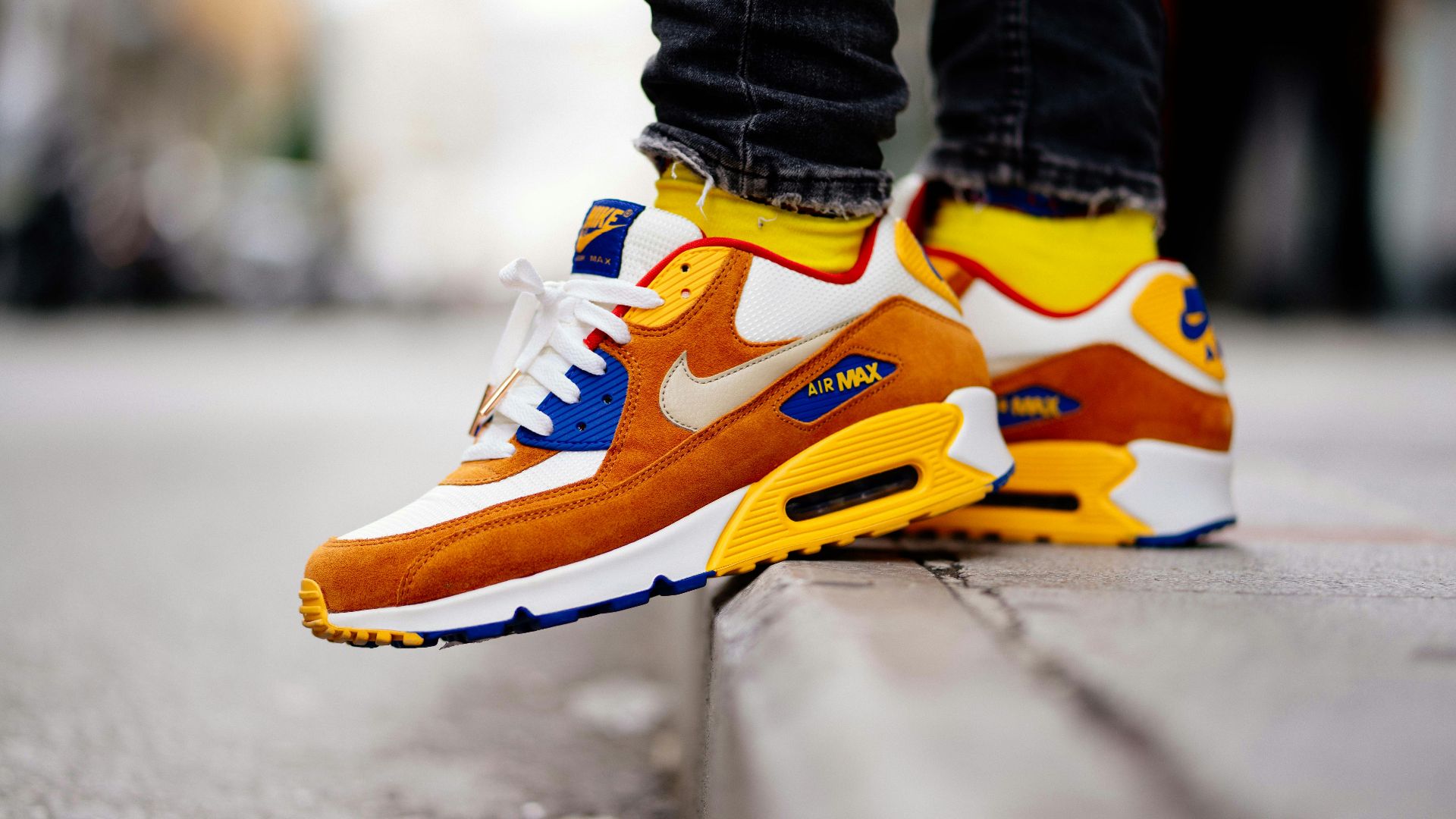 close-up photography of person wears brown-and-white Nike Air Max