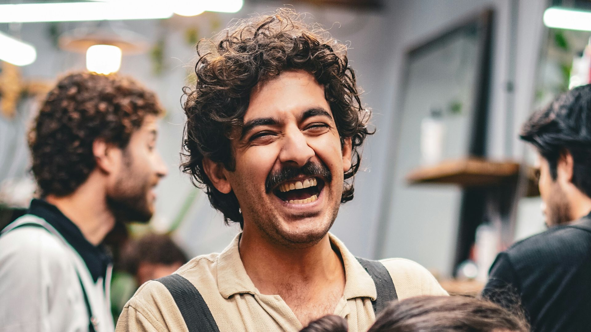Barber laughs while cutting a client's hair.