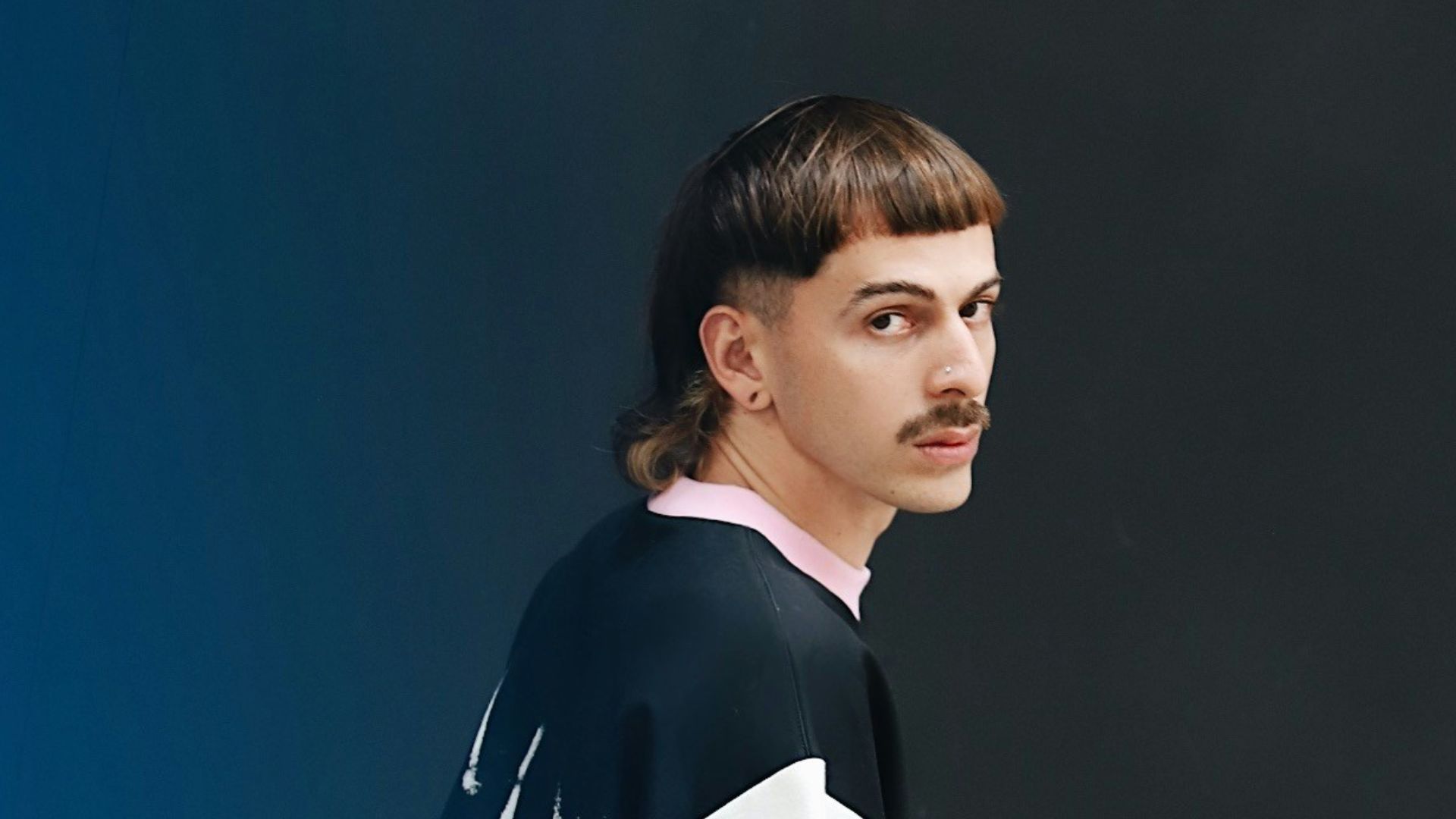 a man standing in front of a blue wall