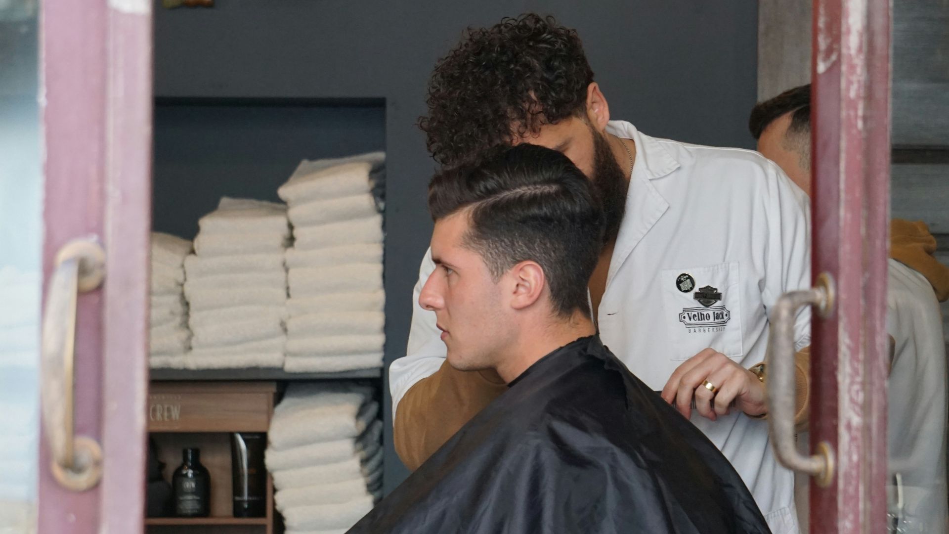 man in white shirt sitting on barber chair