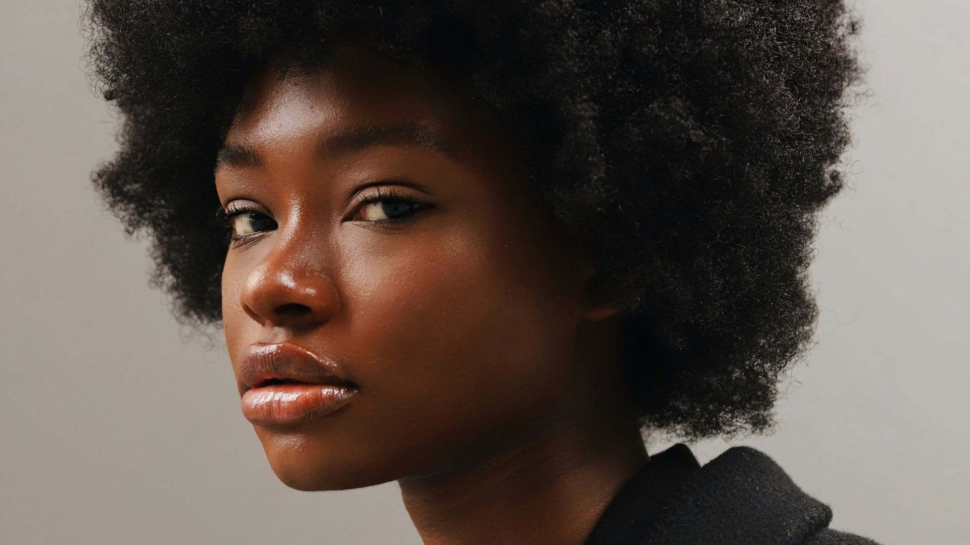 a woman with an afro is looking at the camera