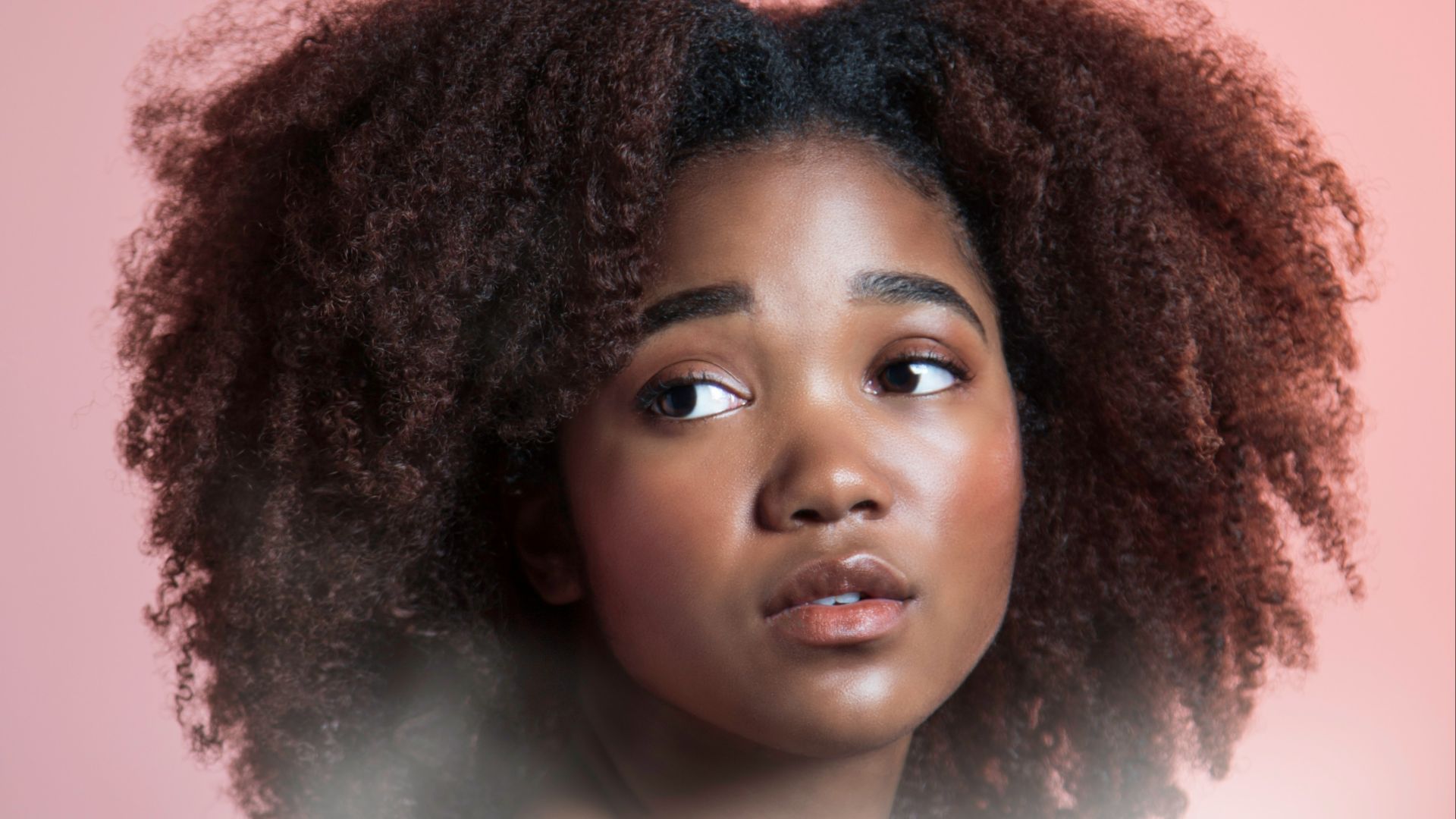 a woman with an afro is looking at the camera