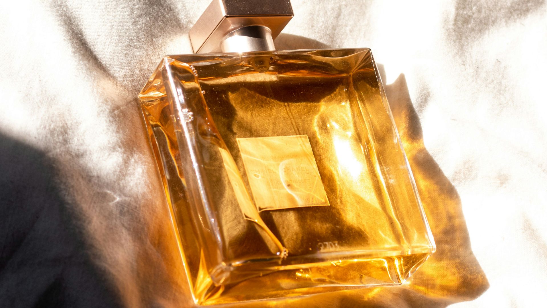 gold perfume bottle on white textile