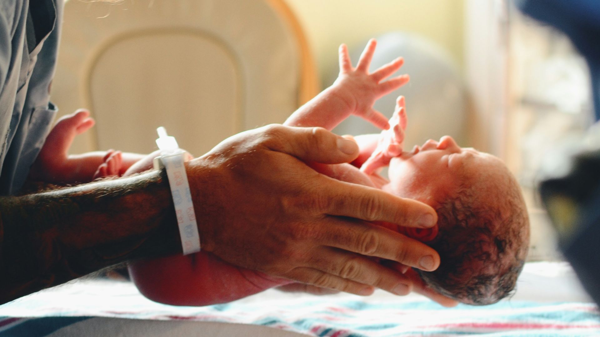 person wearing gray shirt putting baby on scale