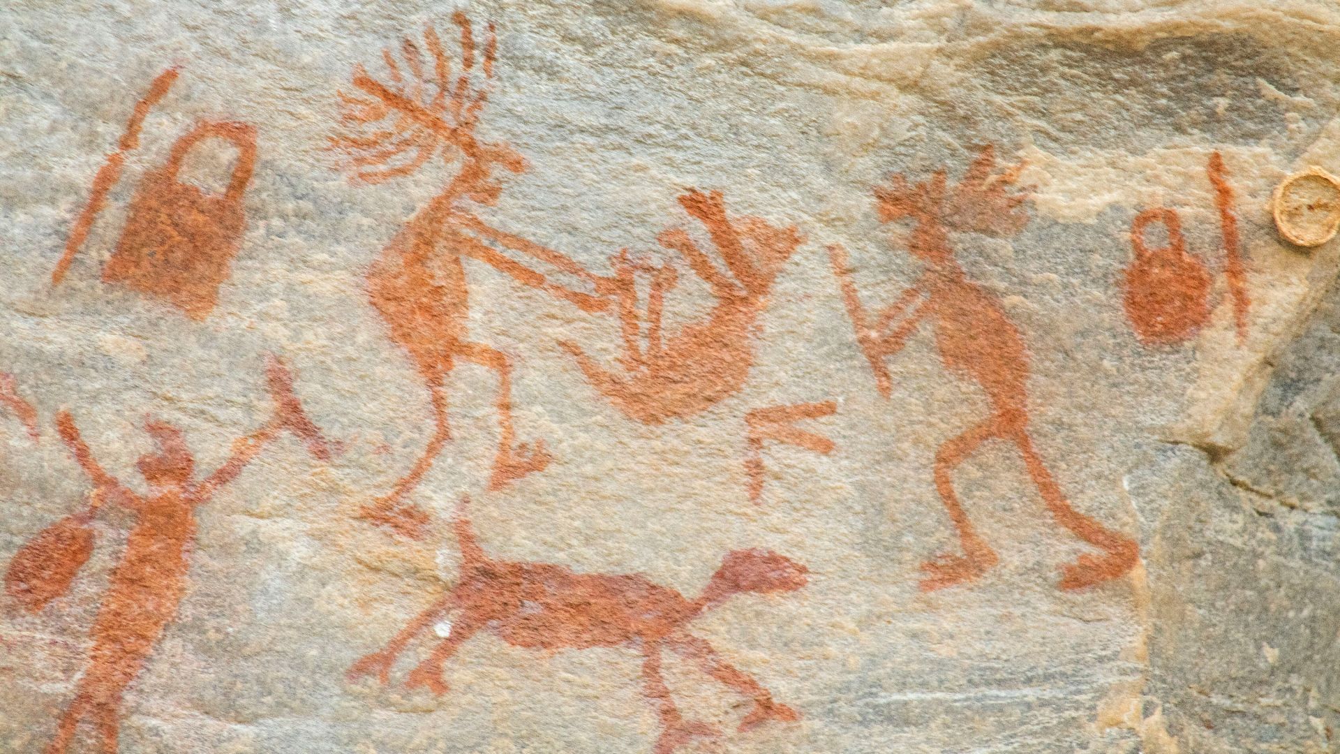 a rock painting of people and animals on it
