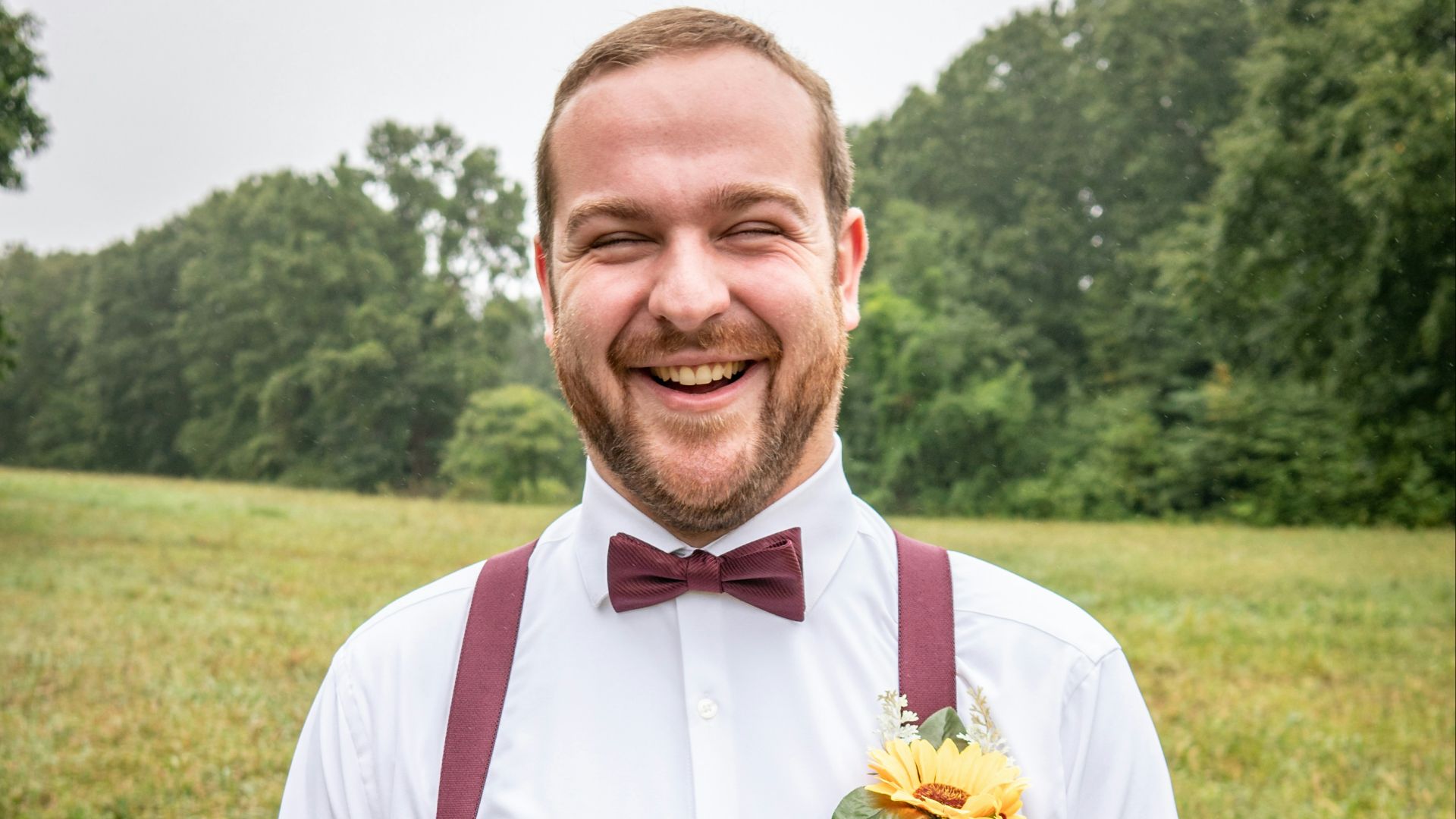 man in white dress shirt and gray pants standing on green grass field during daytime