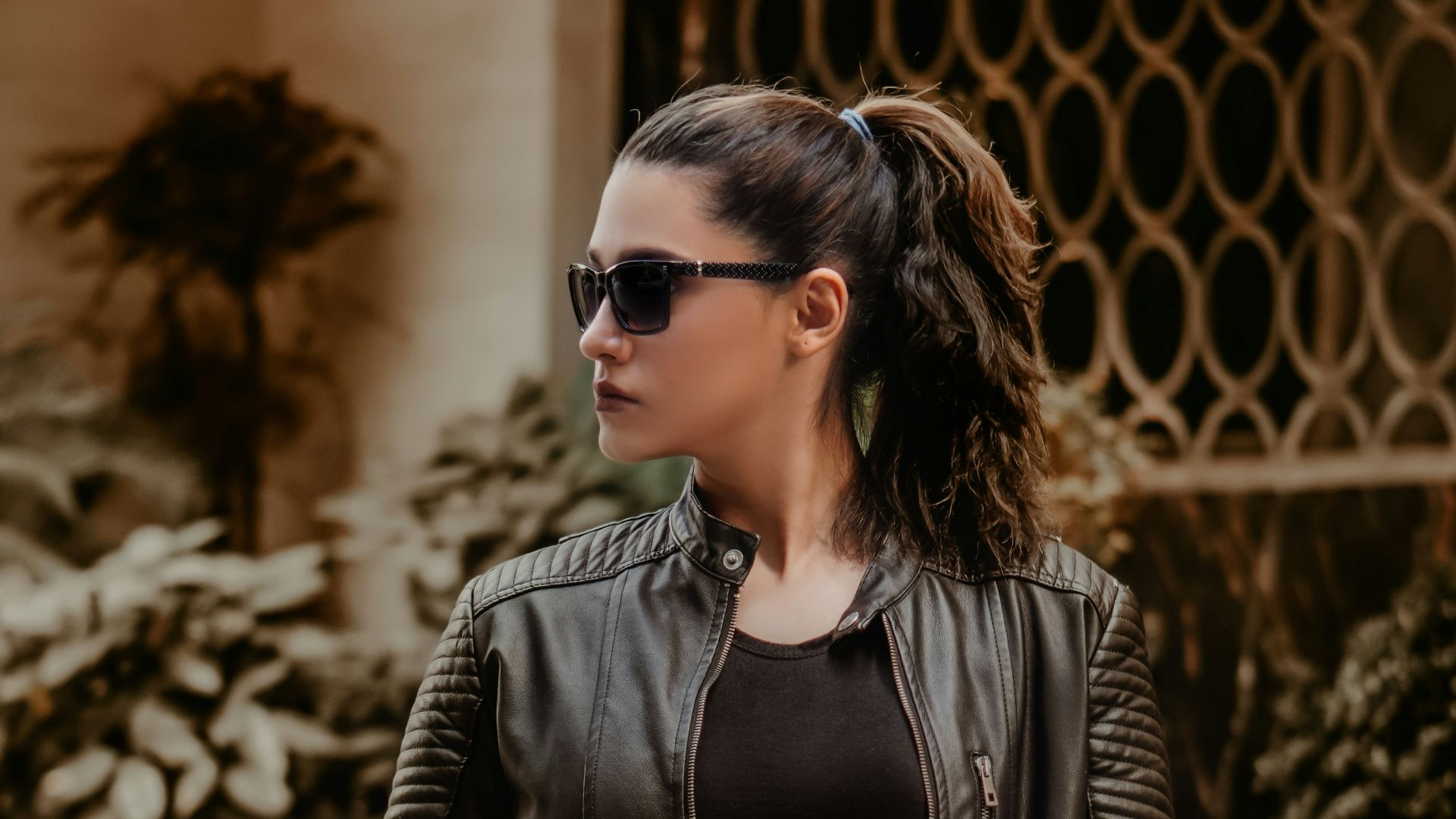 woman in black leather jacket wearing black sunglasses