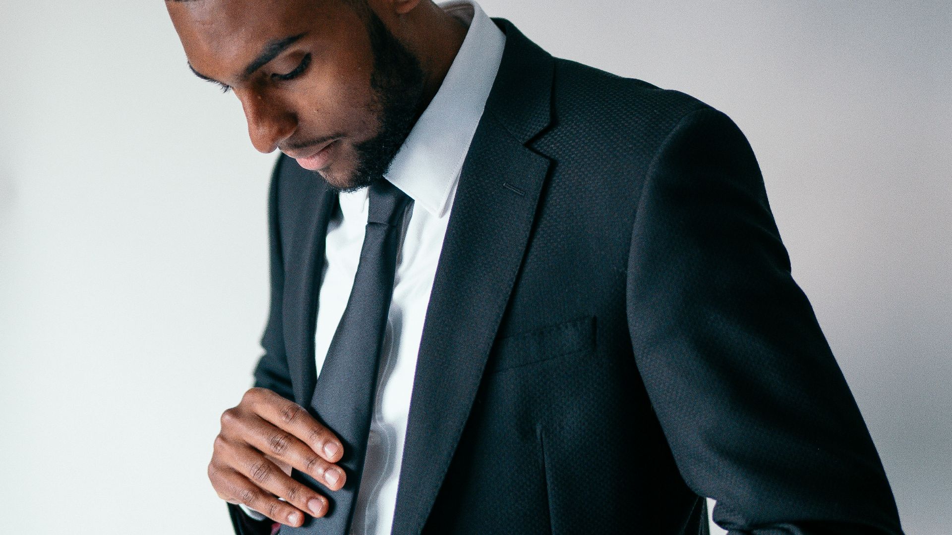 man in black suit holding black smartphone
