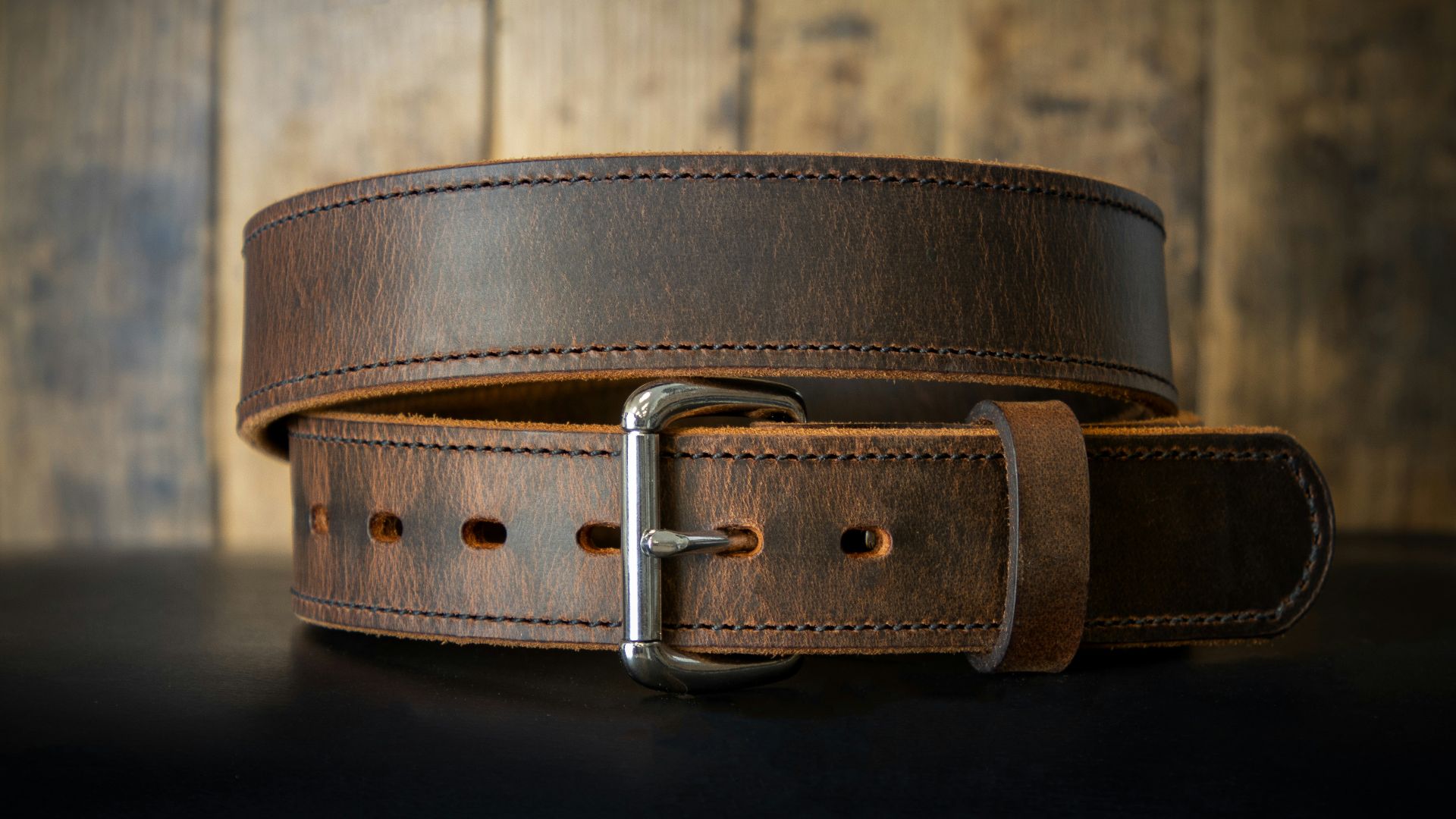 a leather belt on a black surface