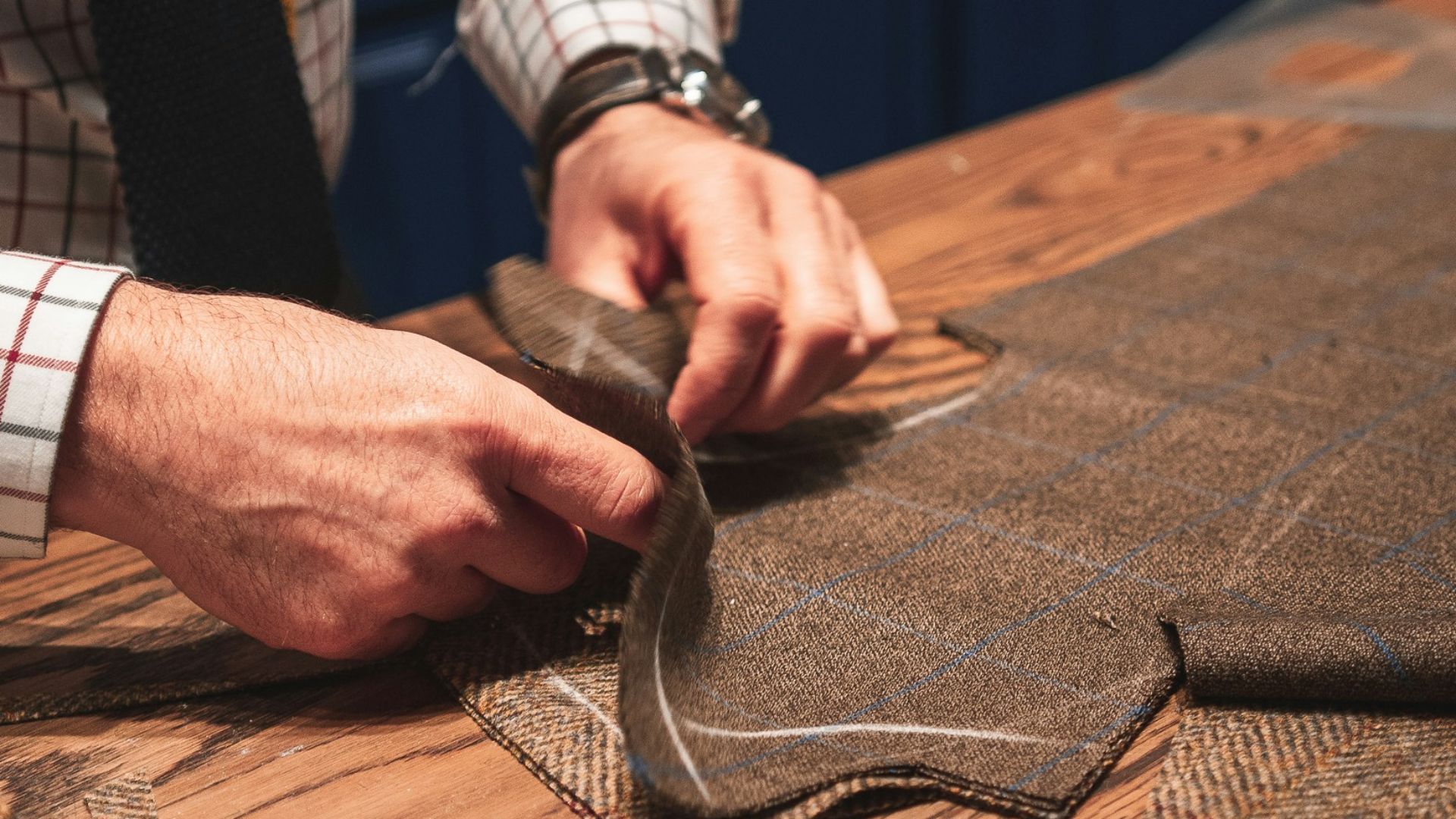 person in black suit holding brown leather bag