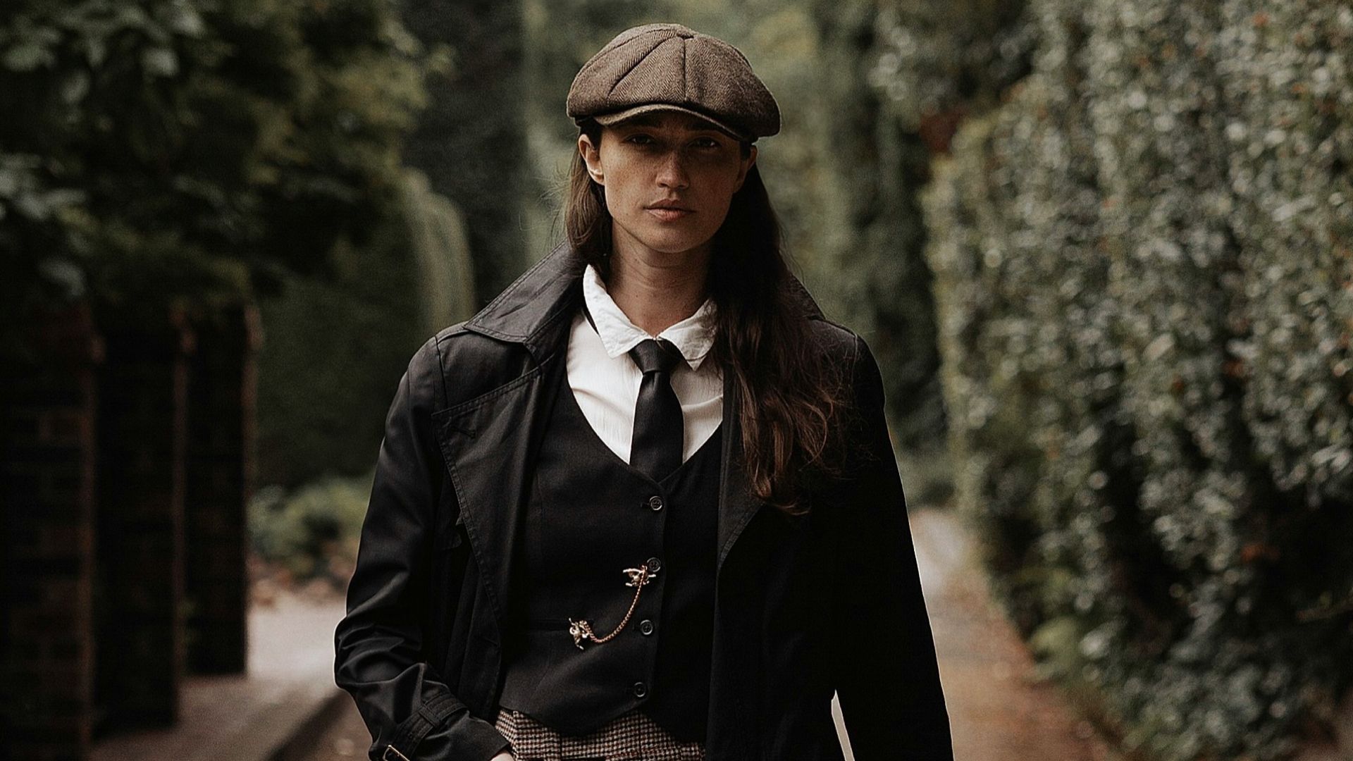 a woman walking down a street in a suit and tie