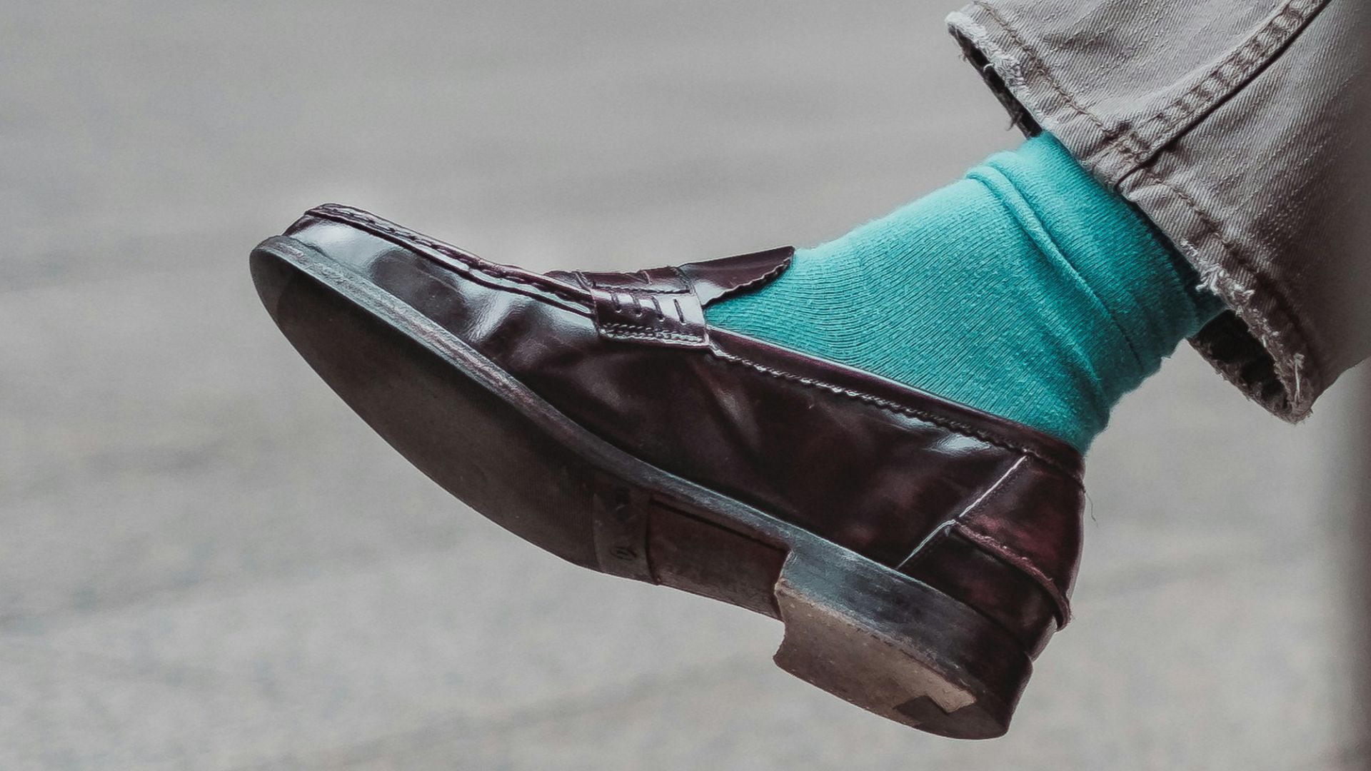 person showing unpaired brown leather dress shoe