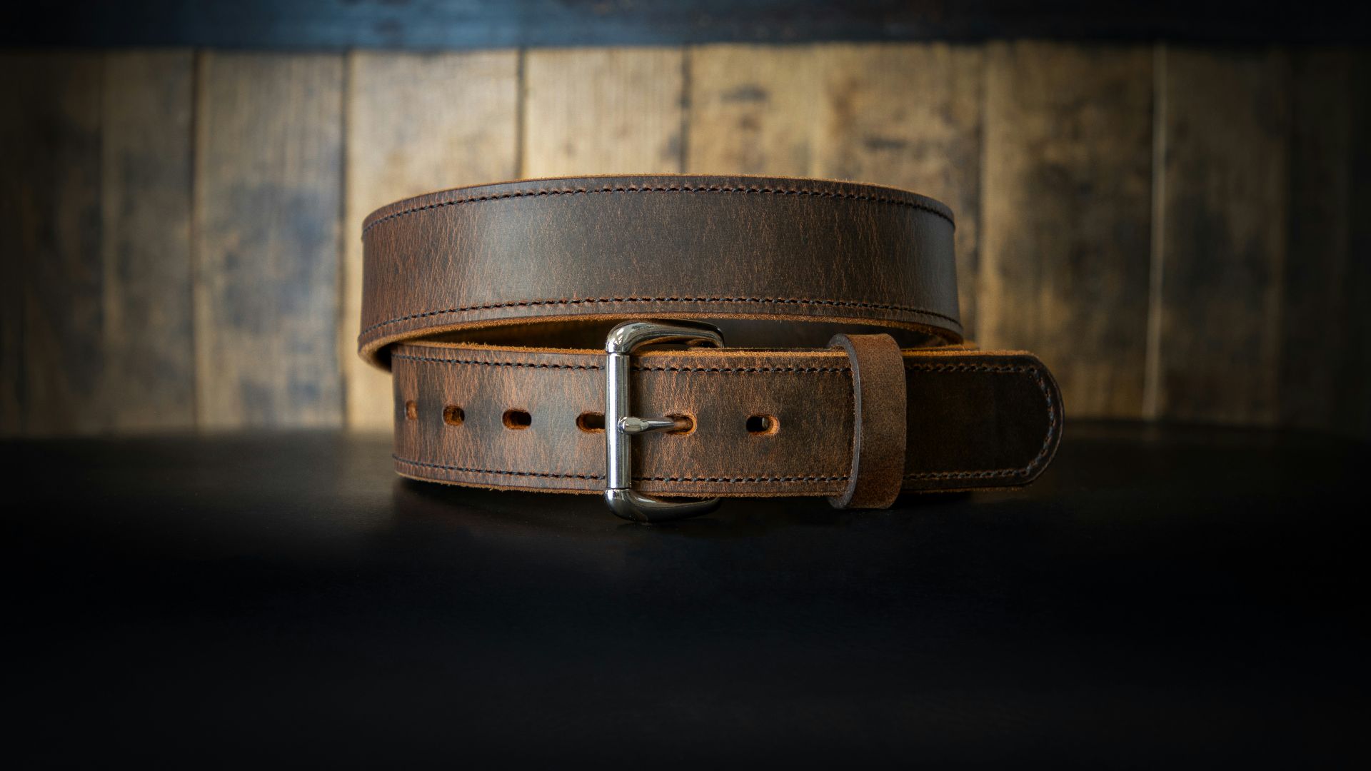 a leather belt on a black surface