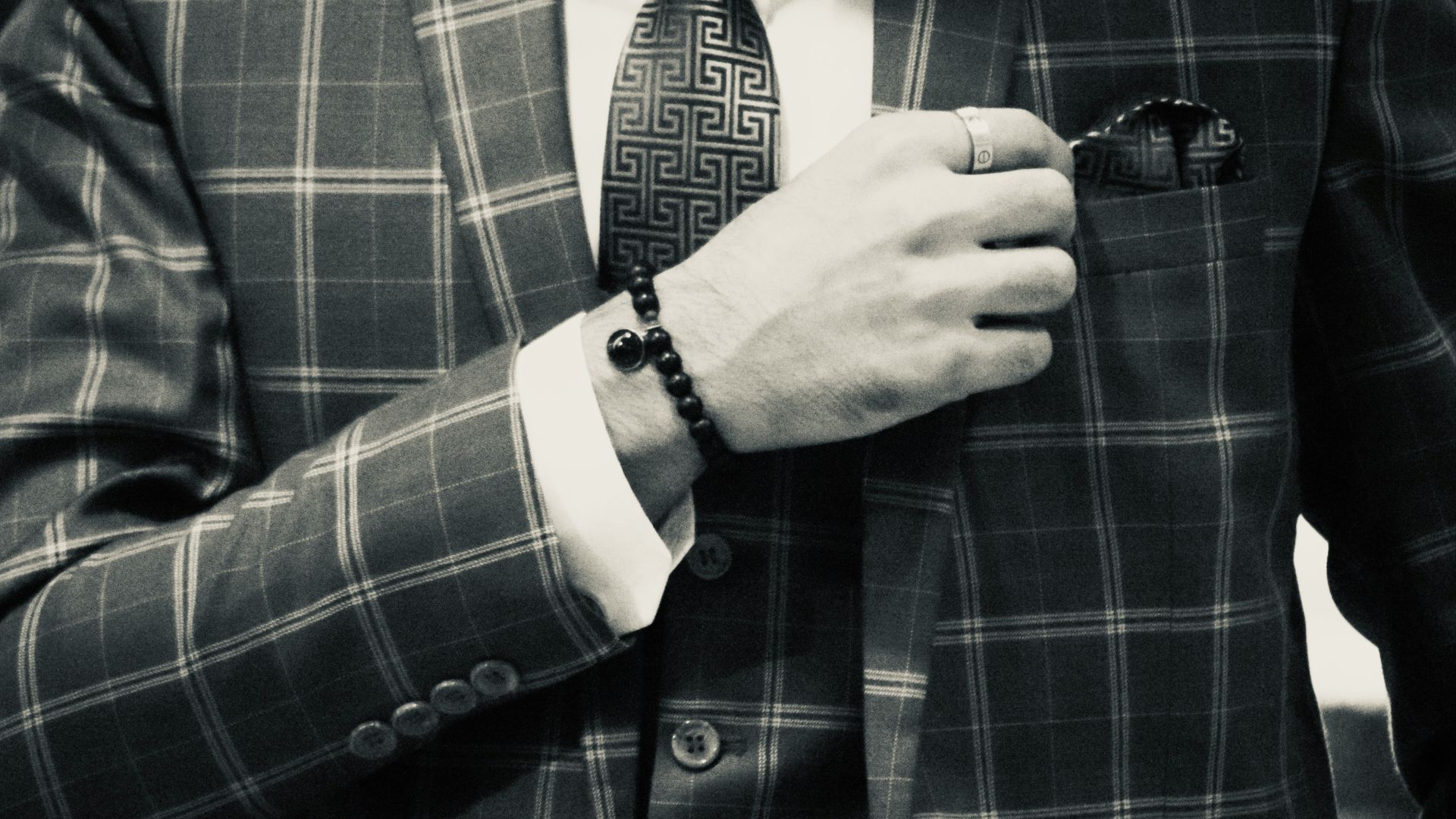 a man in a suit adjusting his tie