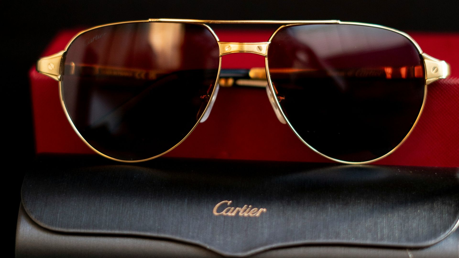 A pair of sunglasses sitting on top of a red case