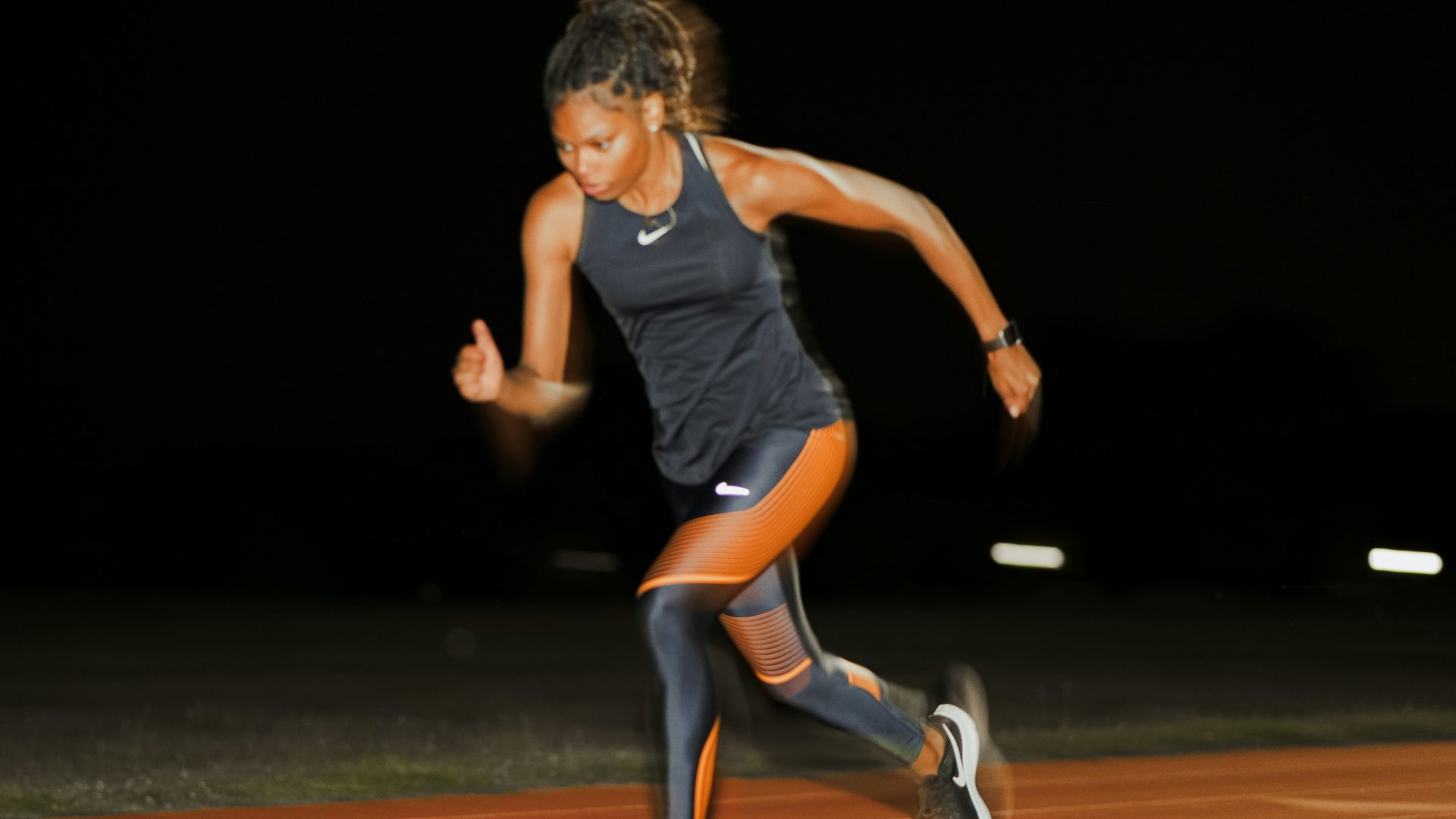 A woman running on a running track at night